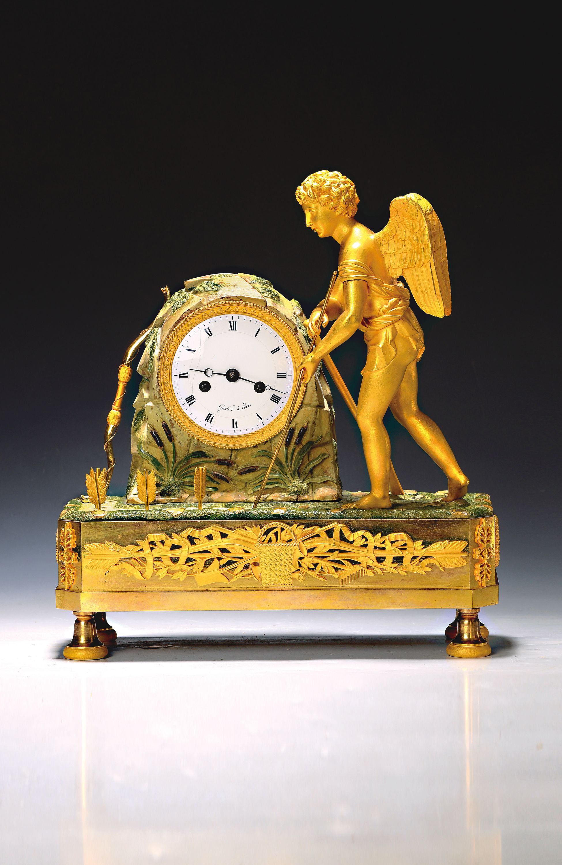Pendule, Frankreich, um 1820, Bronze mit alter Vergoldung, im Sockel Applikation von Gartengeräten, darauf stehender Amor als Gärtner seine Pfeile ...