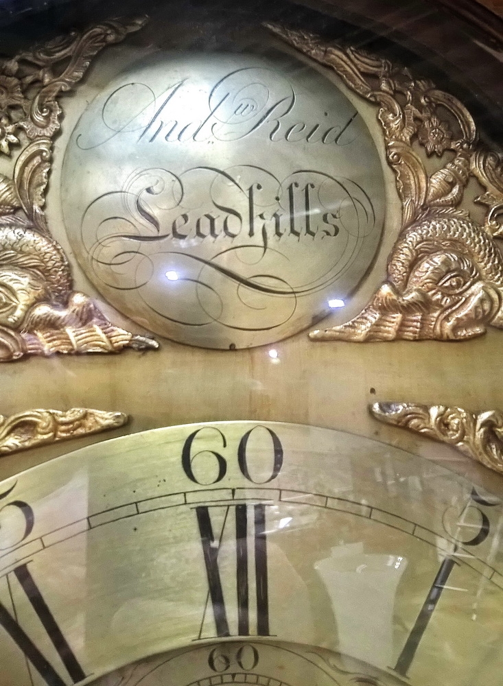 Detail a: Standuhr, England, um 1800, einteiliges Holzgehäuse, Mittelteil abgesetzt, kannelierte Säulen, Oberteil aufgesetzt, Sprenggiebel, Bogenzifferblatt ...