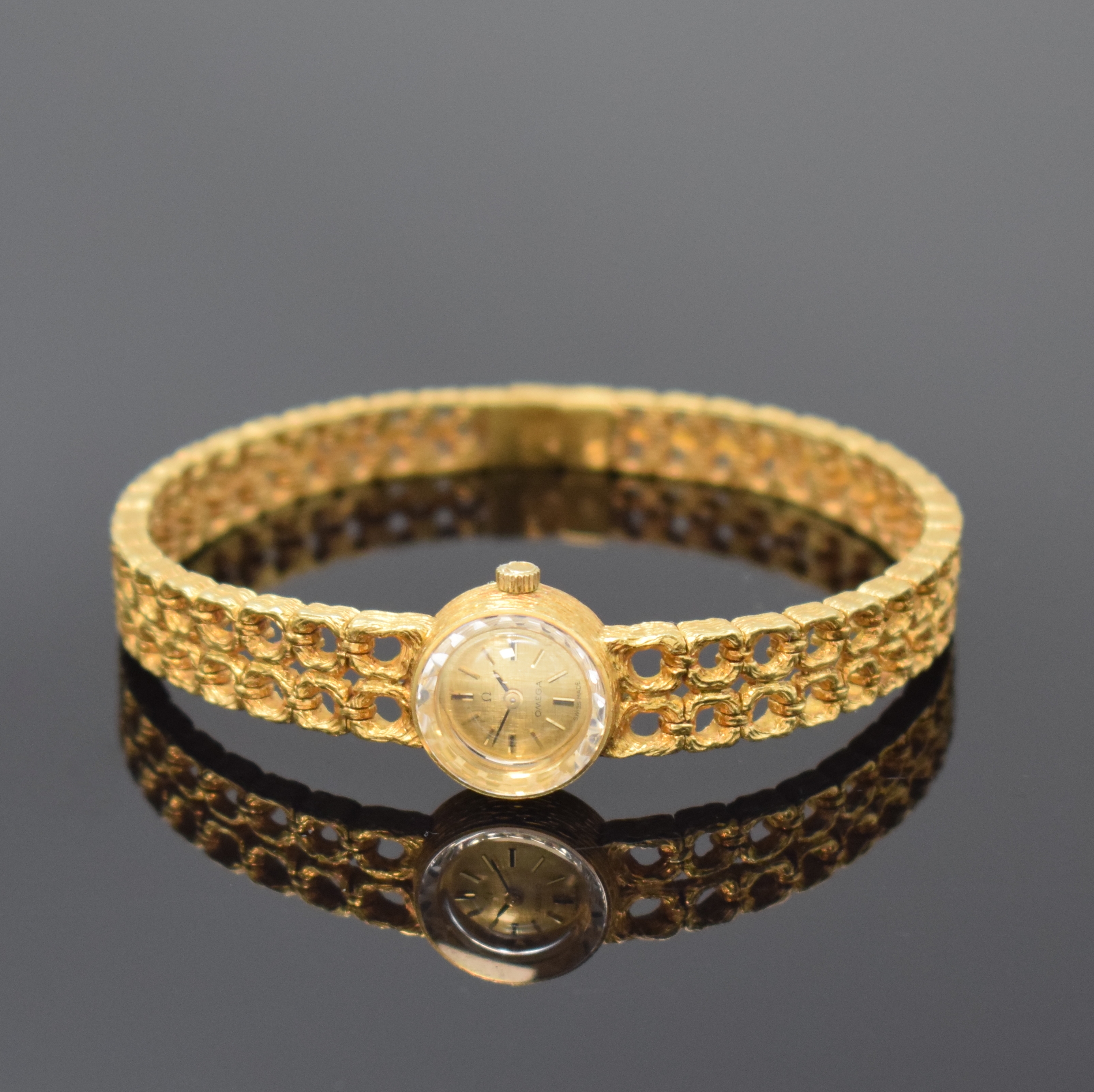 OMEGA Damenarmbanduhr in GG 750/000, Schweiz um 1968, Handaufzug, Boden aufgedr., gold. Zifferbl. m. aufgel. Std.-Ind., schwarze Zeiger, rotverg. ...