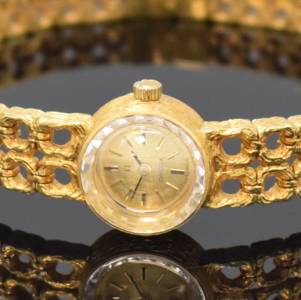 Detail a: OMEGA Damenarmbanduhr in GG 750/000, Schweiz um 1968, Handaufzug, Boden aufgedr., gold. Zifferbl. m. aufgel. Std.-Ind., schwarze Zeiger, rotverg. ...