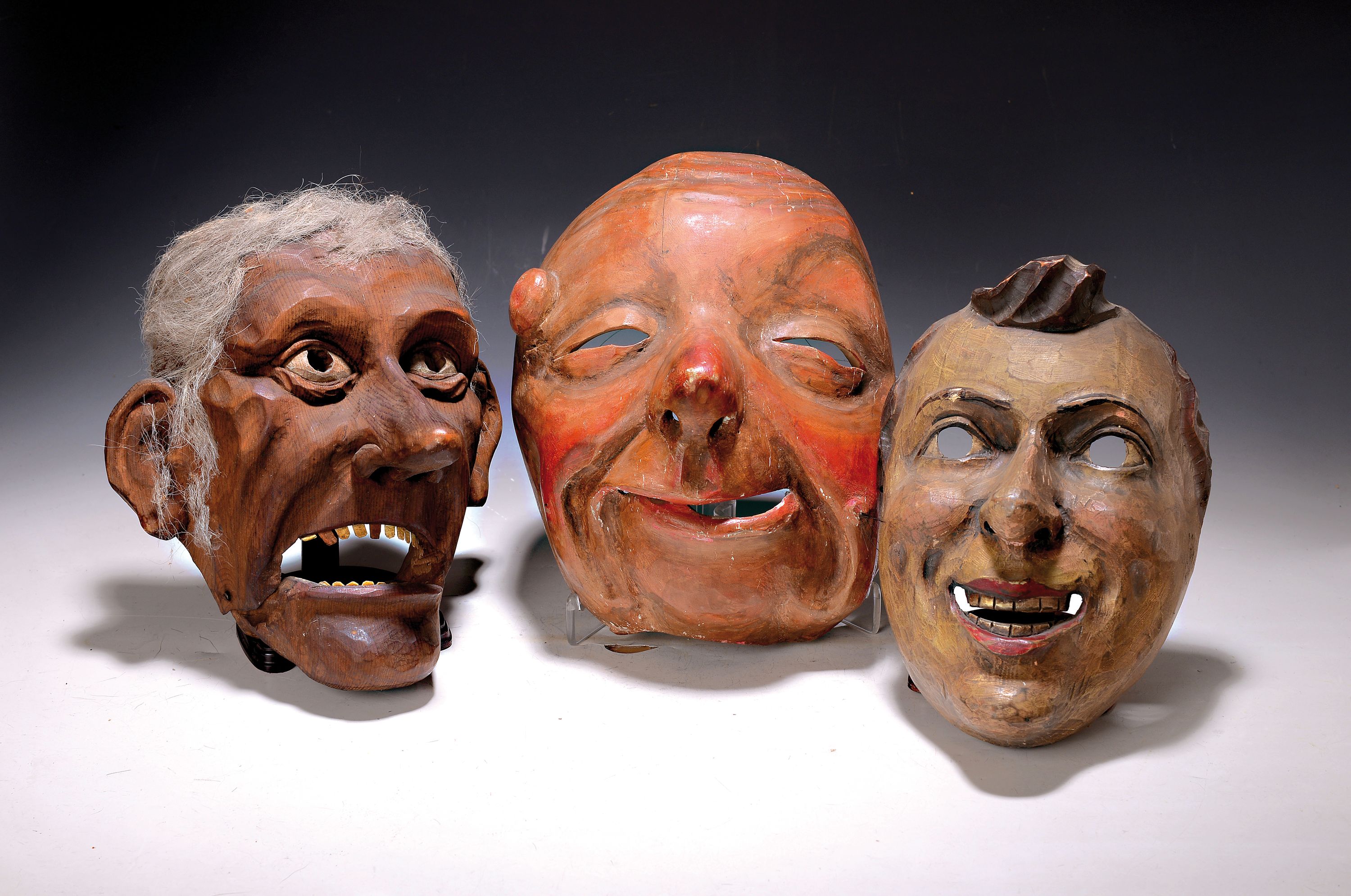 Drei Masken, Schweiz/alemannisch, 19. und 20. Jh., Holz geschnitzt, a. verzerrtes Gesicht mit Warze, ca. 28 x 19 cm, Riss; b. Maske mit beweglichem ...