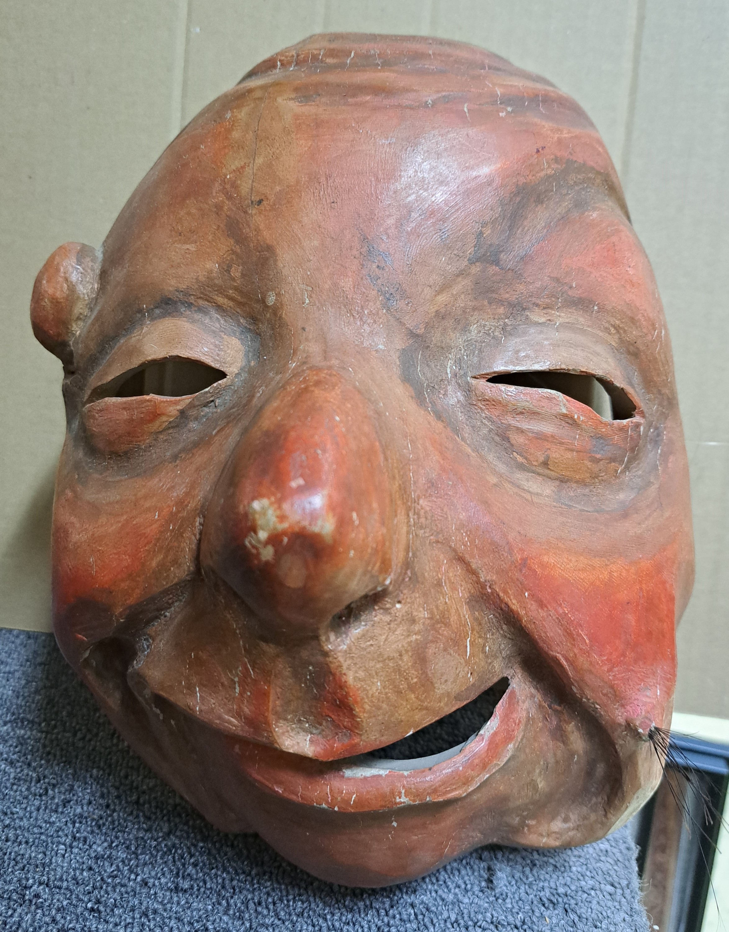 Detail a: Drei Masken, Schweiz/alemannisch, 19. und 20. Jh., Holz geschnitzt, a. verzerrtes Gesicht mit Warze, ca. 28 x 19 cm, Riss; b. Maske mit beweglichem ...