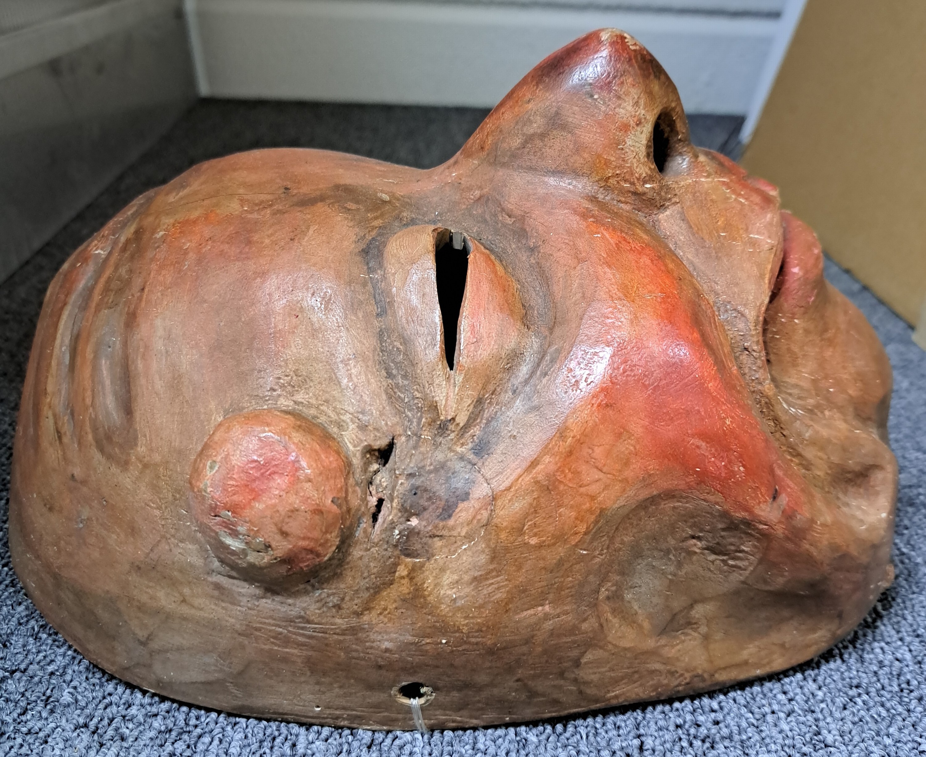 Detail b: Drei Masken, Schweiz/alemannisch, 19. und 20. Jh., Holz geschnitzt, a. verzerrtes Gesicht mit Warze, ca. 28 x 19 cm, Riss; b. Maske mit beweglichem ...