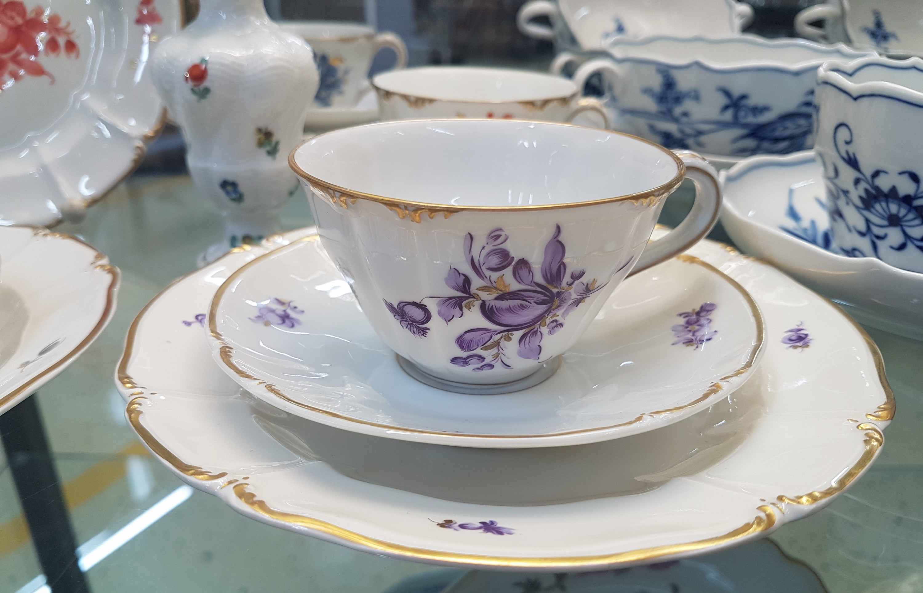 Detail b: 6 Kaffeegedecke und ein Väschen, Nymphenburg, 20. Jh., Blumenmalerei, Goldrand, Teller D. 17.5 cm