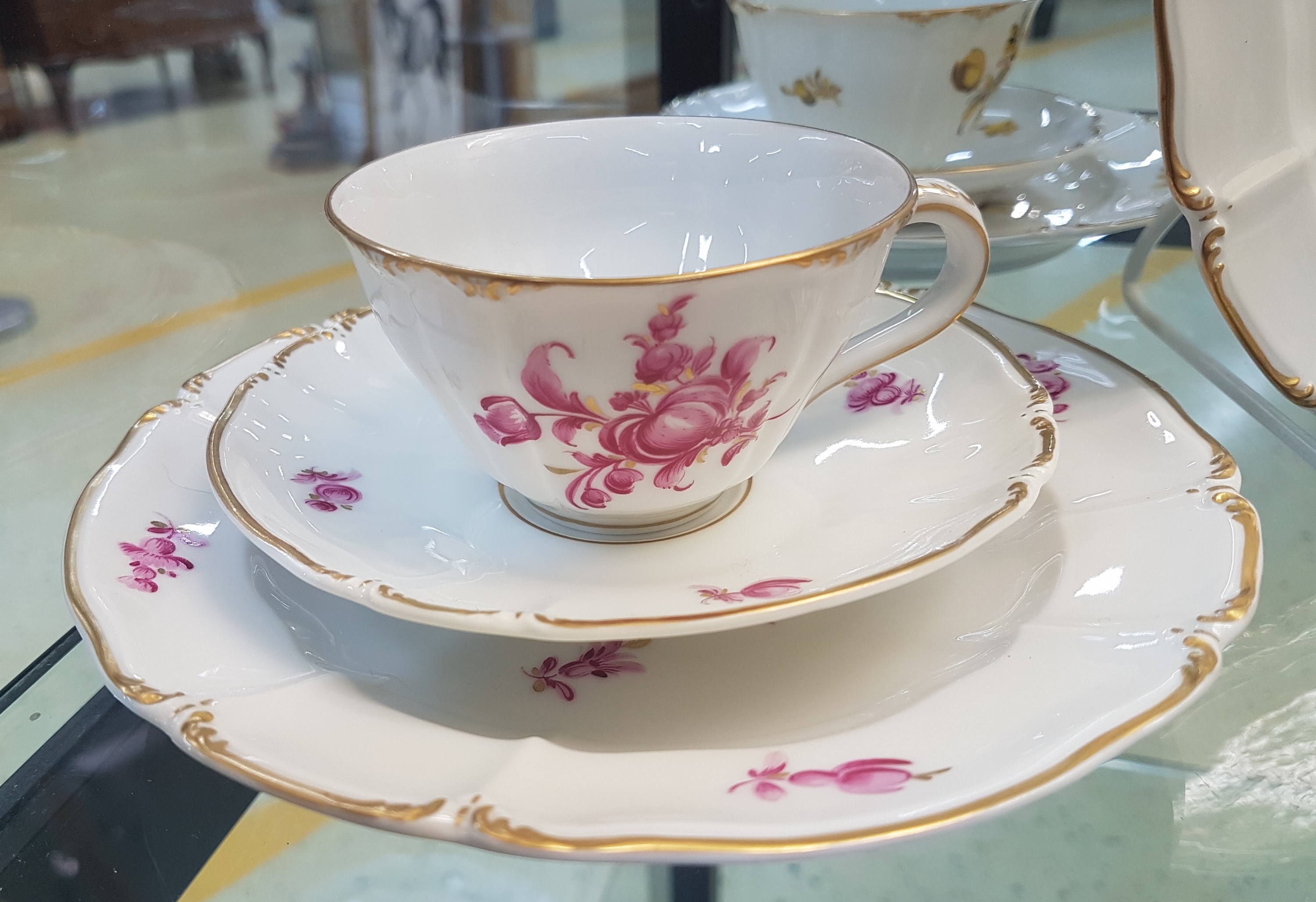 Detail d: 6 Kaffeegedecke und ein Väschen, Nymphenburg, 20. Jh., Blumenmalerei, Goldrand, Teller D. 17.5 cm