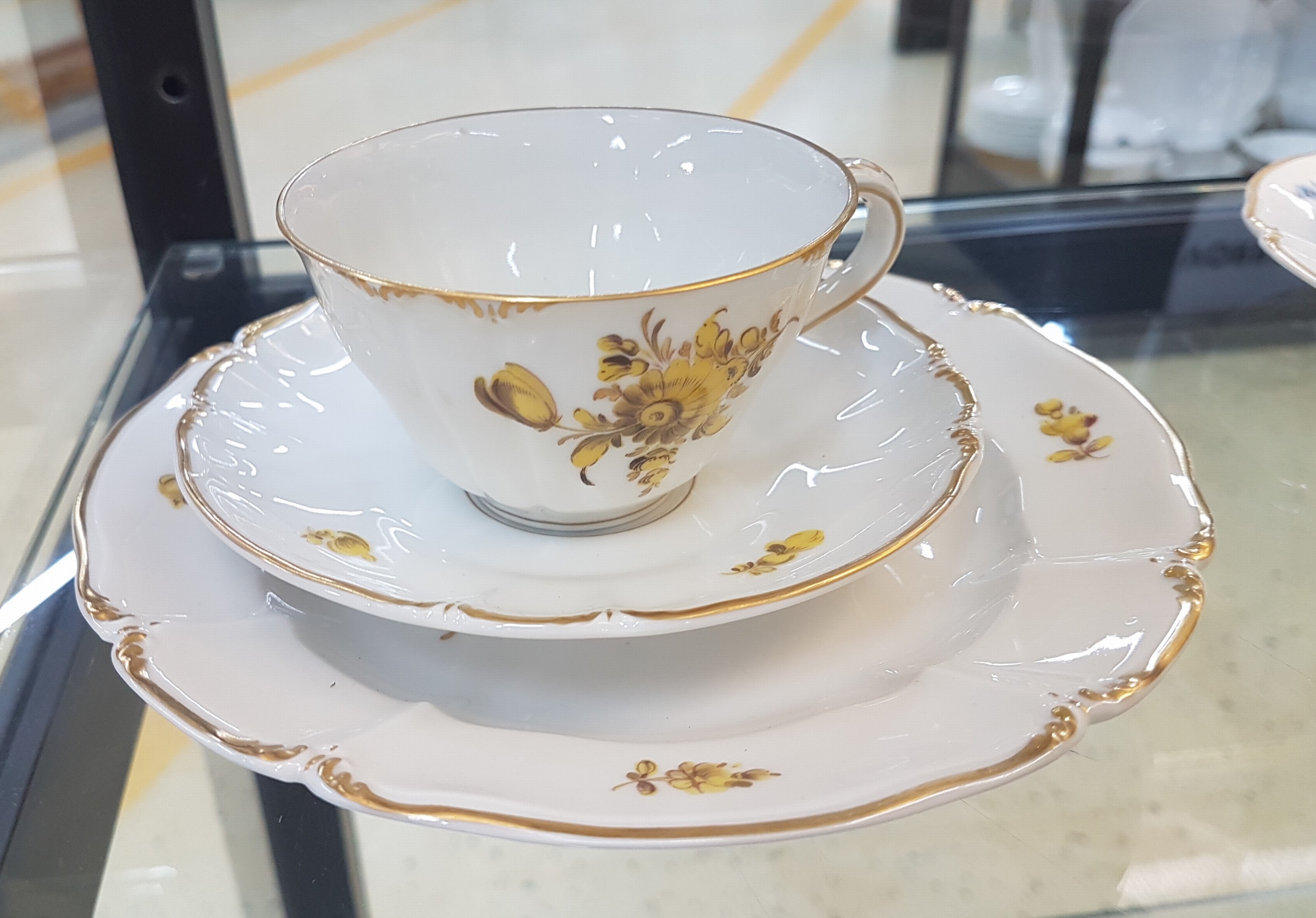 Detail h: 6 Kaffeegedecke und ein Väschen, Nymphenburg, 20. Jh., Blumenmalerei, Goldrand, Teller D. 17.5 cm