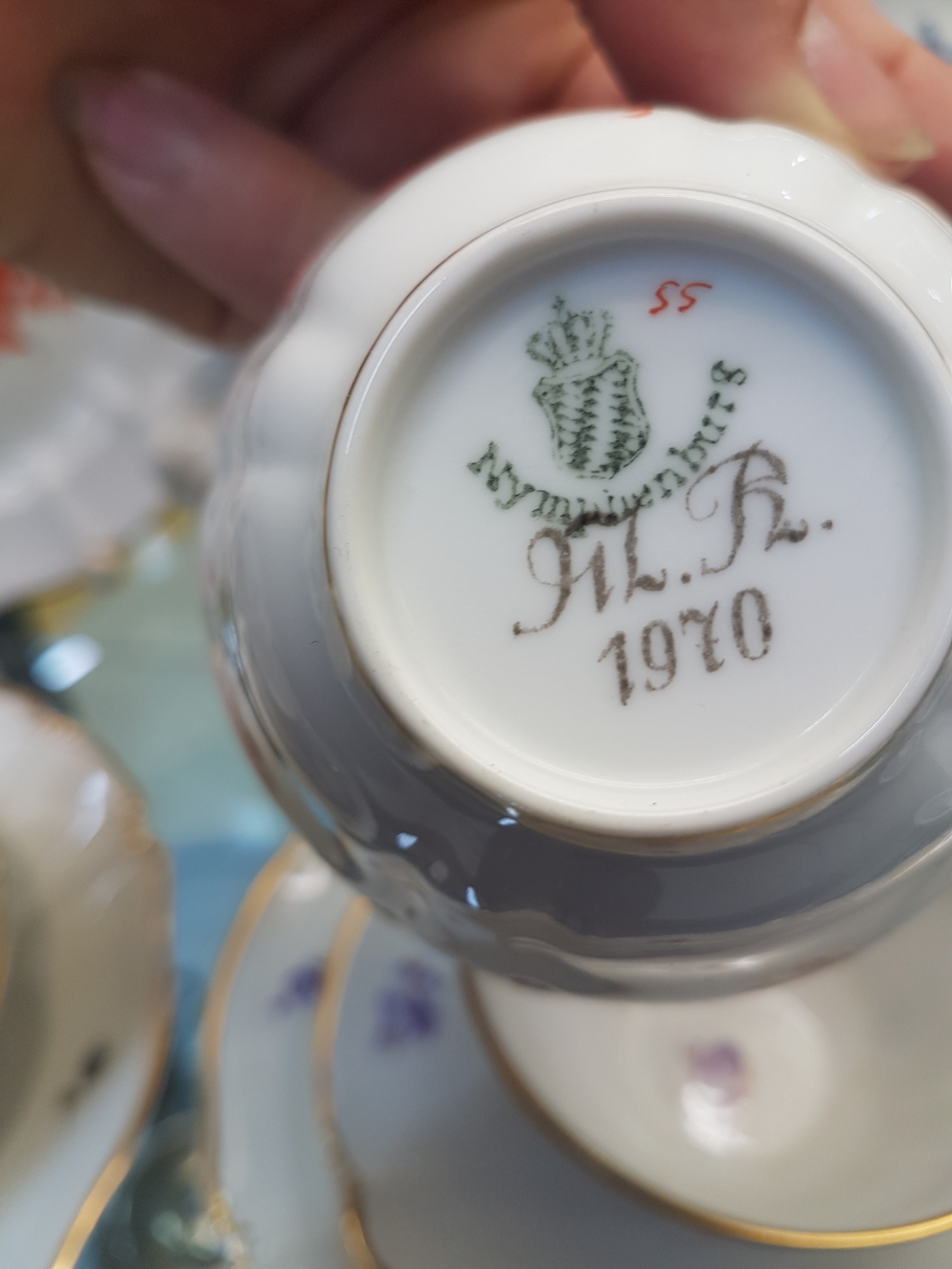 Detail k: 6 Kaffeegedecke und ein Väschen, Nymphenburg, 20. Jh., Blumenmalerei, Goldrand, Teller D. 17.5 cm