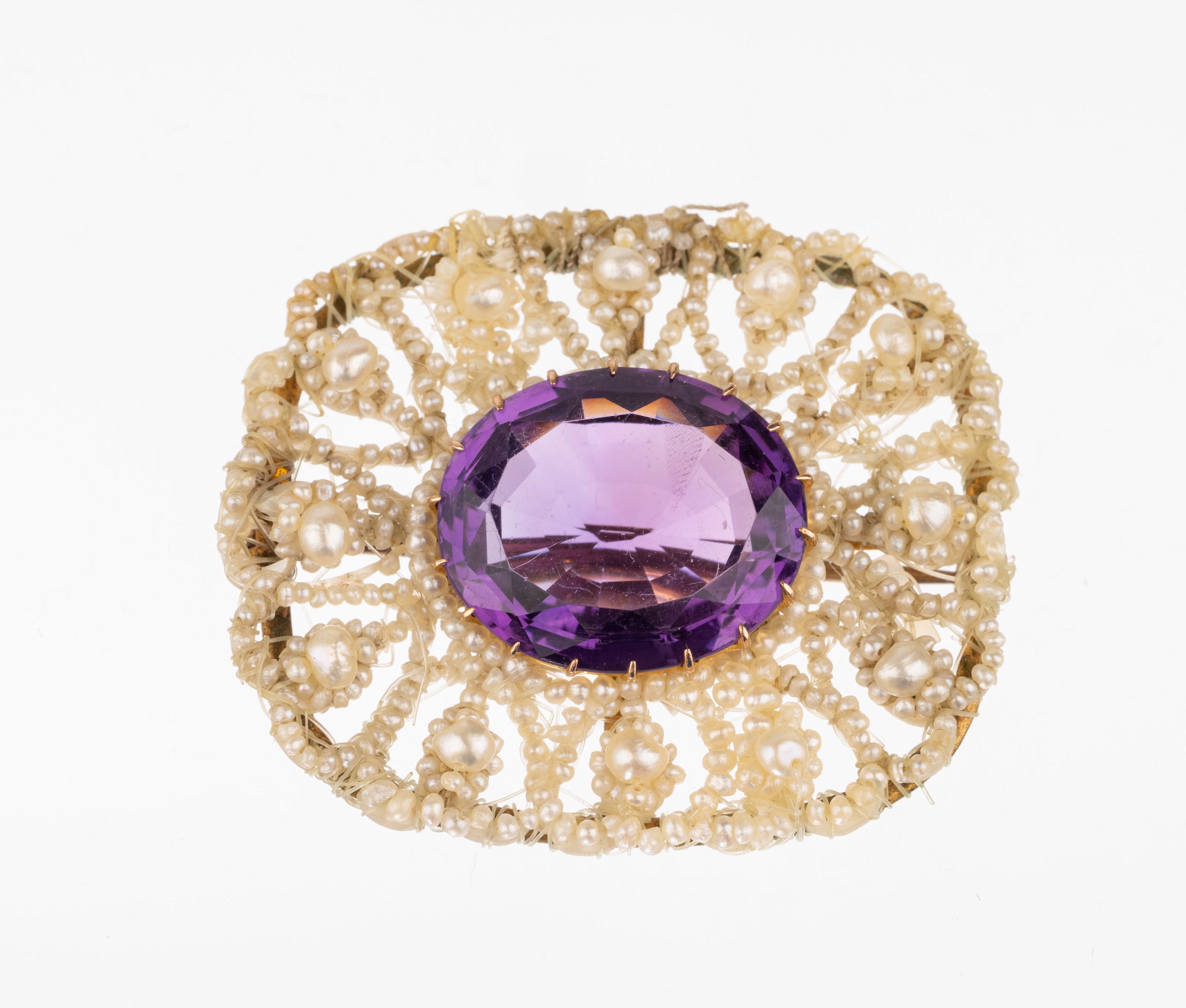 Orientperl-Amethyst-Brosche, England um 1850, ovalfacett. Amethyst ca. 6 ct in GG 625/000 gefaßt, umgeben von einem Perlmutt Rahmen mit feiner ...