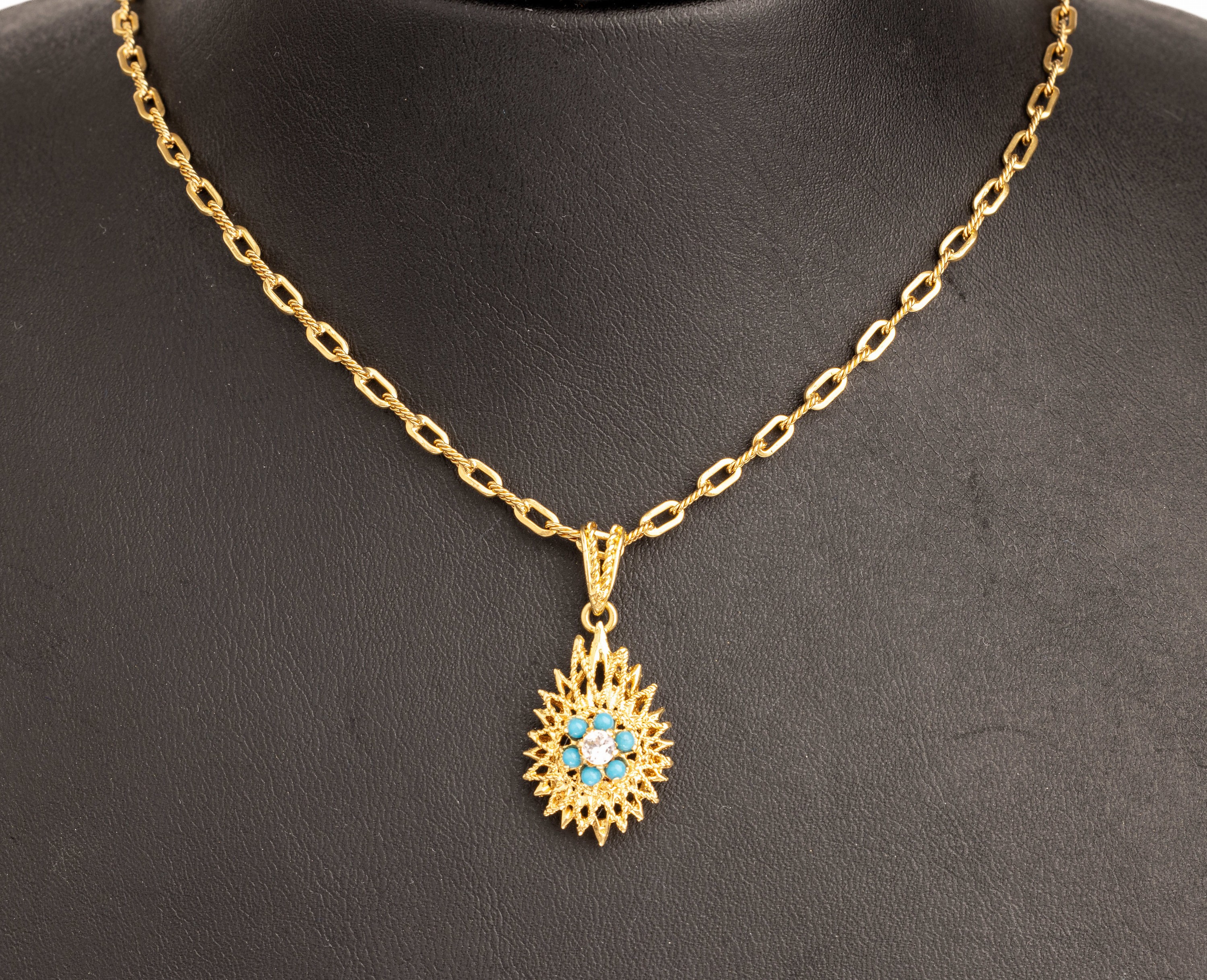18 kt Gold Türkis Anhänger, GG 750/000, strahlenförm., kl. Türkis- und Strassbes., an Kette L. ca. 60 cm, Federringschließe, ca. 16.6 g