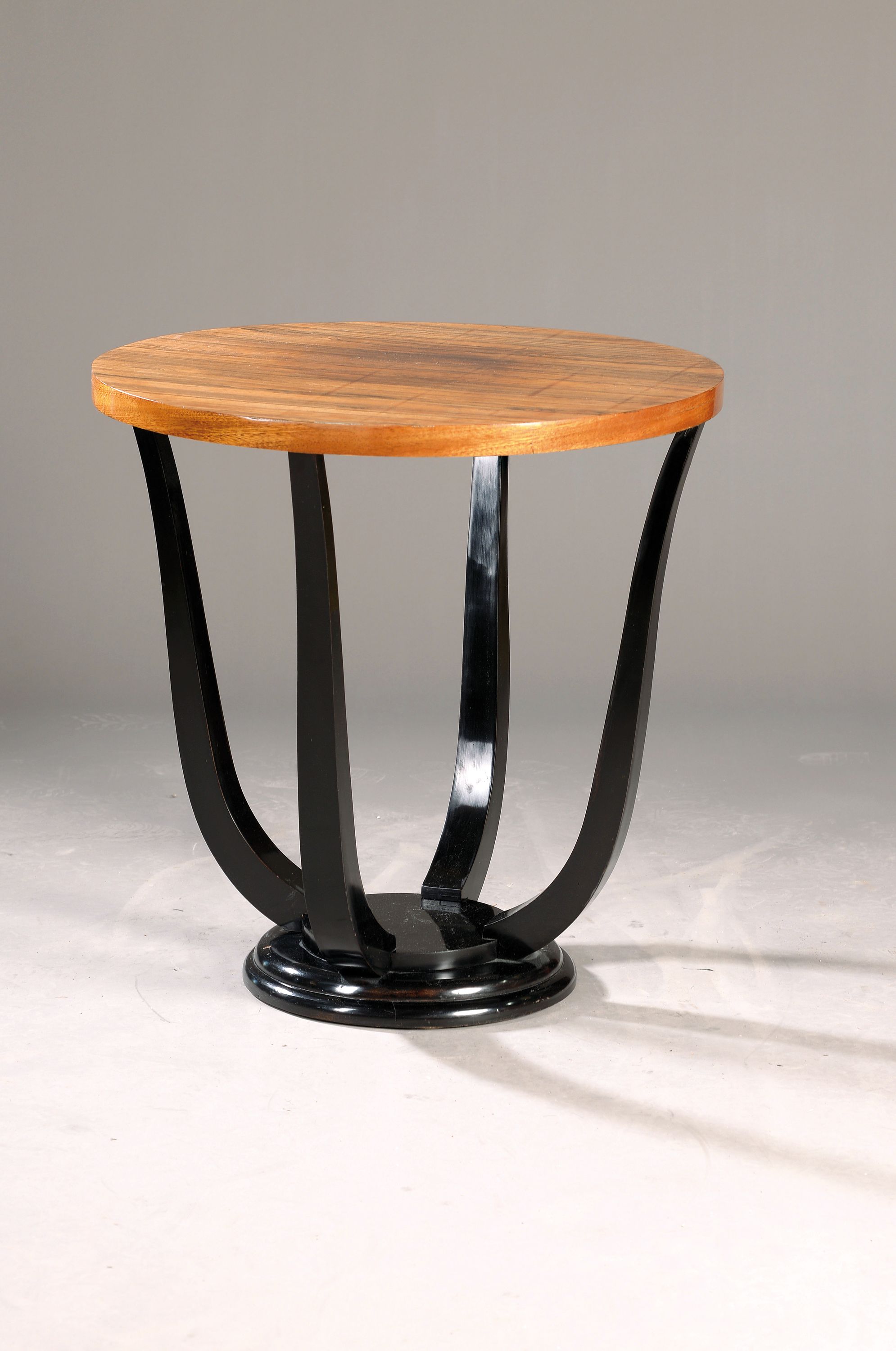 Beistelltisch, Art-Deco, Frankreich, um 1930 , Nußbaumfurnier, vier Auslegerbeine auf runder Sockelplatte, schwarz lackiert, H. ca. 68 cm, D. ca. 65 ...