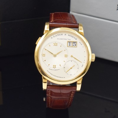 26783108a - A. LANGE & SÖHNE very rare & early Lange 1 reference 101.001 in 18k yellow gold, manual winding, solid gold back 6-times screwed, silvered dial, applied gilded indices, separate dials for hours/minutes, second, power reserve indicator and big date, gilded alpha hands, nickel silver movement calibre 901.0, Glashutter stripe, 53 jewels, 9 screwed down gold chatons, Glucydur-balance with Breguet-hairspring, in 5 Lagen reguliert, original leather strap with original 18k yellow gold buckle, diameter approx. 38,5 mm, original box, Hangtag and papers enclosed, condition 2