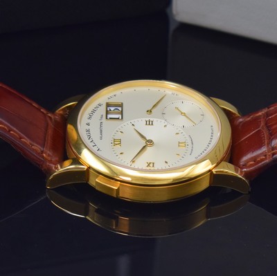 26783108b - A. LANGE & SÖHNE very rare & early Lange 1 reference 101.001 in 18k yellow gold, manual winding, solid gold back 6-times screwed, silvered dial, applied gilded indices, separate dials for hours/minutes, second, power reserve indicator and big date, gilded alpha hands, nickel silver movement calibre 901.0, Glashutter stripe, 53 jewels, 9 screwed down gold chatons, Glucydur-balance with Breguet-hairspring, in 5 Lagen reguliert, original leather strap with original 18k yellow gold buckle, diameter approx. 38,5 mm, original box, Hangtag and papers enclosed, condition 2