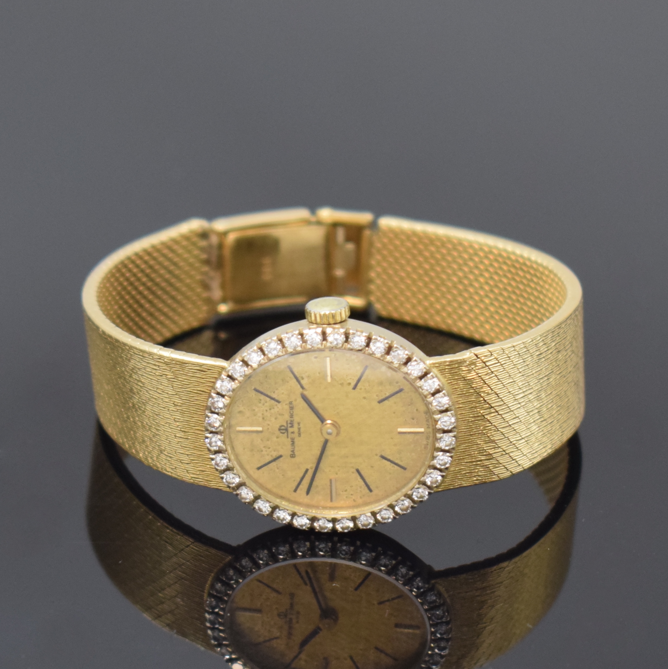BAUME & MERCIER Damenarmbanduhr in GG 750/000 mit Diamanten, Schweiz um 1975, Handaufzug, Milanaiseband, Boden aufgedr., Lünette aufw. m. Diamanten ...