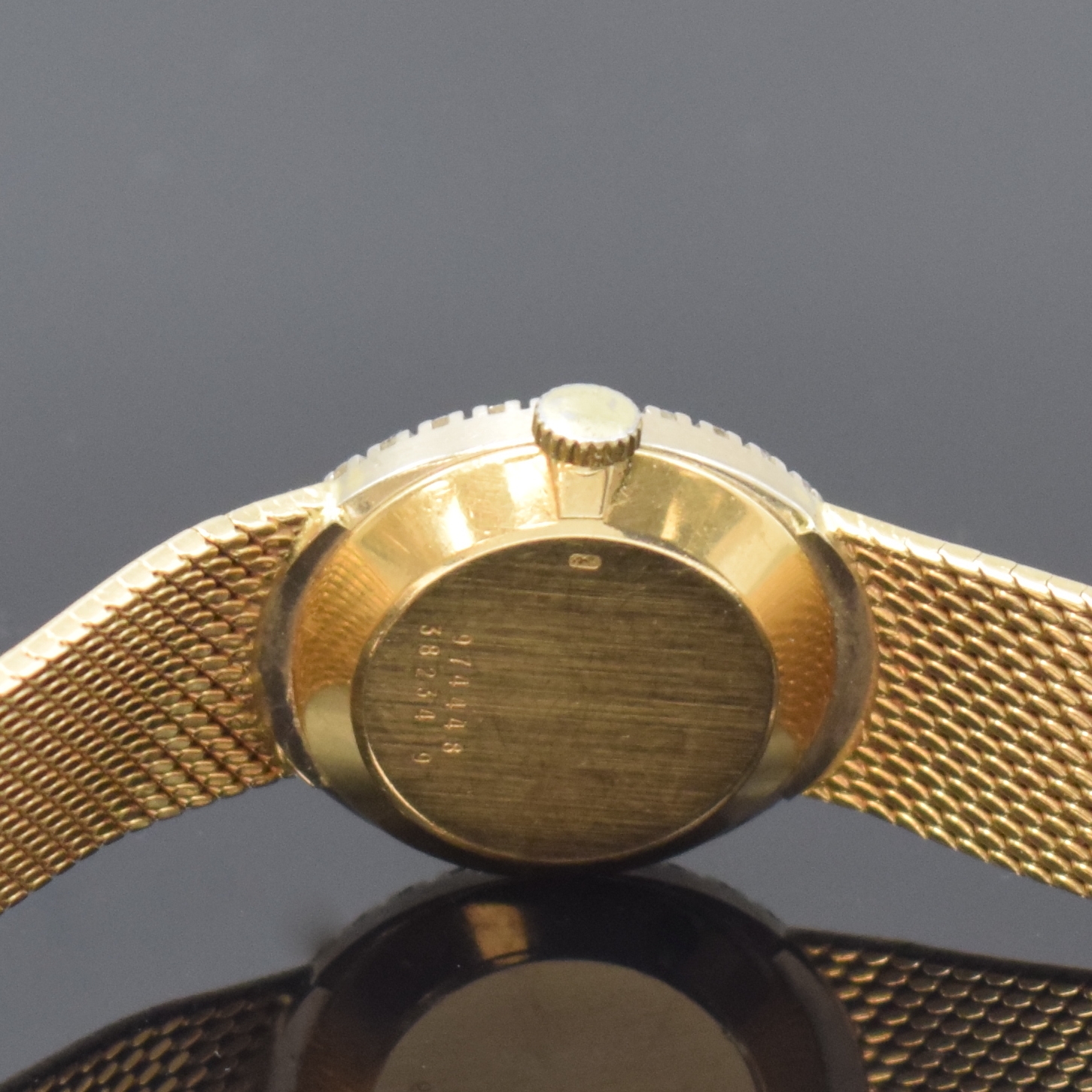 Detail e: BAUME & MERCIER Damenarmbanduhr in GG 750/000 mit Diamanten, Schweiz um 1975, Handaufzug, Milanaiseband, Boden aufgedr., Lünette aufw. m. Diamanten ...