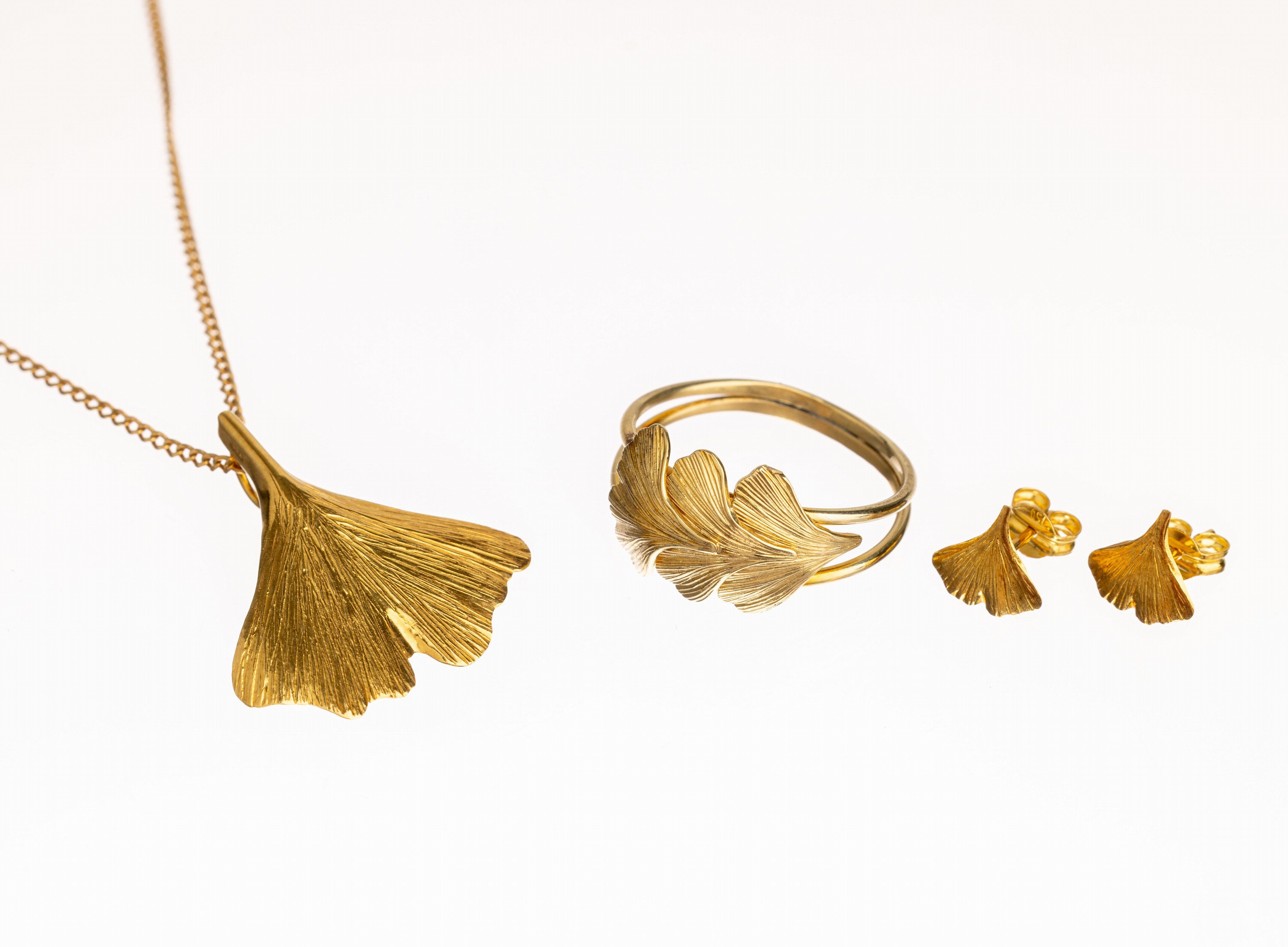 18 kt Gold Ginkgo-Schmuckset, GG 750/000 Ginkgoblätter, best. aus: Paar Ohrstecker und Anhänger mit Kette, L. ca. 58 cm, dazu passend Ring mit ...