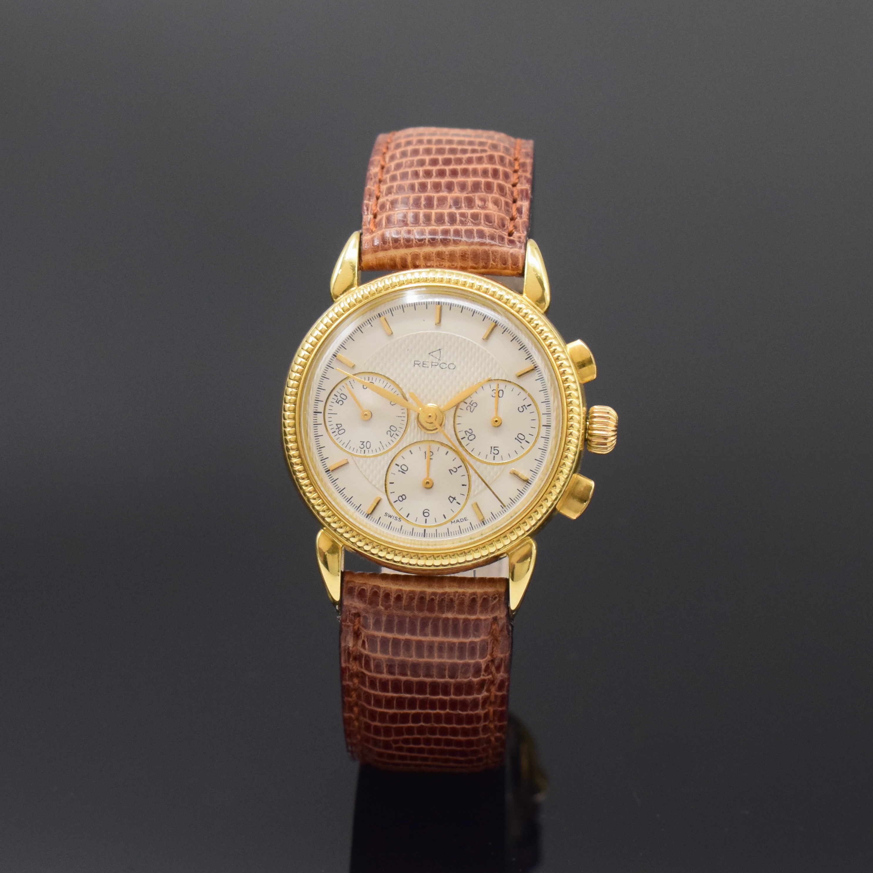 REPCO Armbandchronograph in GG 750/000, Schweiz um 1990, Handaufzug, beids. vergl. Geh., Boden aufgedr., geriffelte Lünette, silb. ...