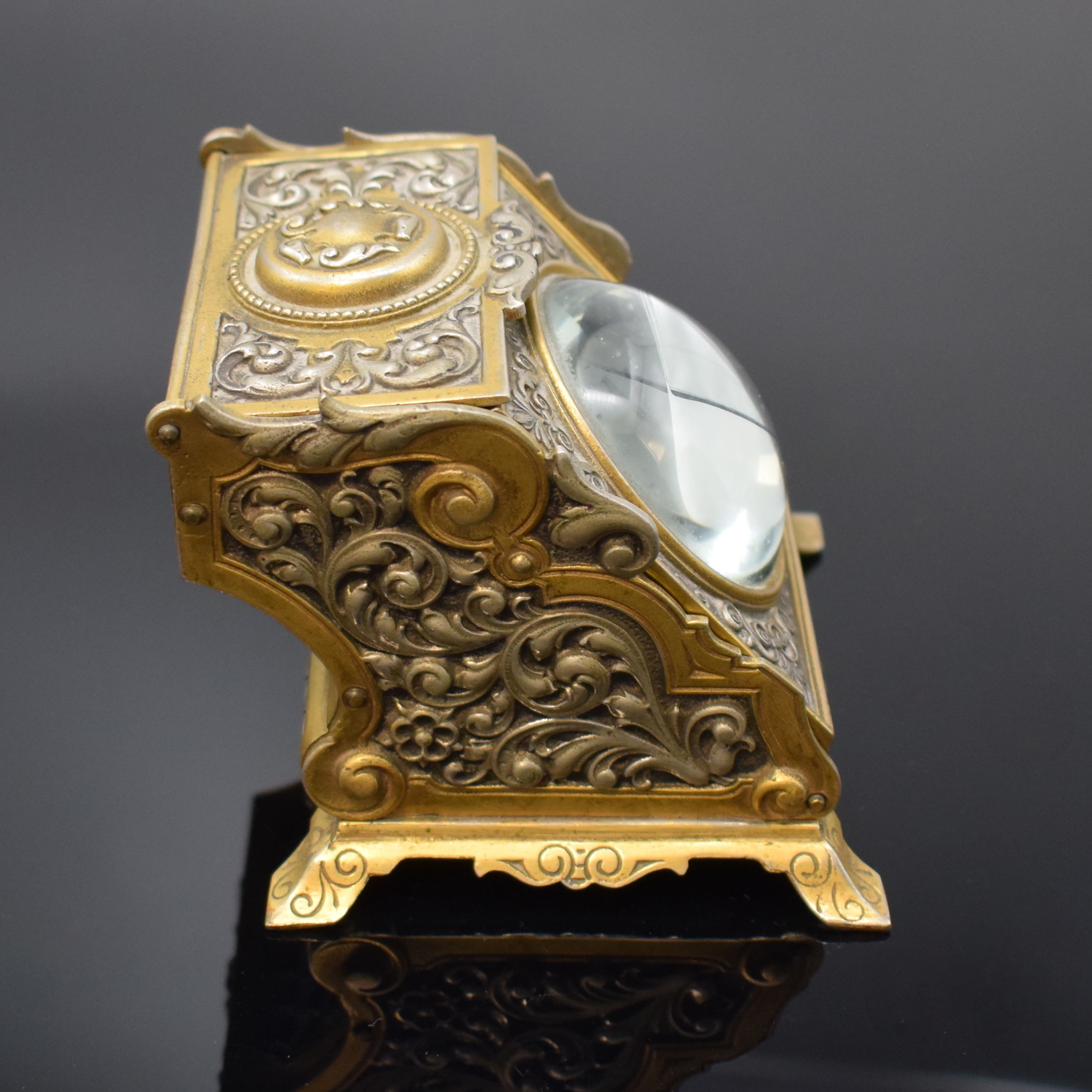 Detail a: Ausgefallener Uhrenständer in Form einer Dose mit Lupenglas und offener Silbertaschenuhr, Schweiz um 1890/1910, floral grav. Uhrenständer in Nickel ...
