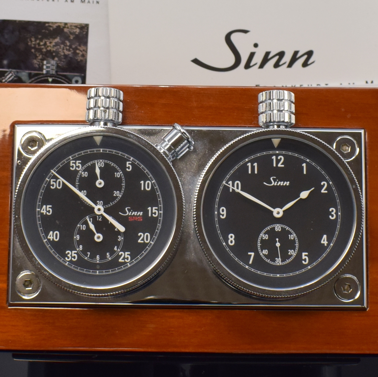Detail a: SINN Rallye-Set auf Holzständer, verchromte Gehäuse auf Metallplatte, links Stoppuhr mit Flyback, Anz. v. 60-Sek., 60-Min. und 12-Std. Stoppz., ...