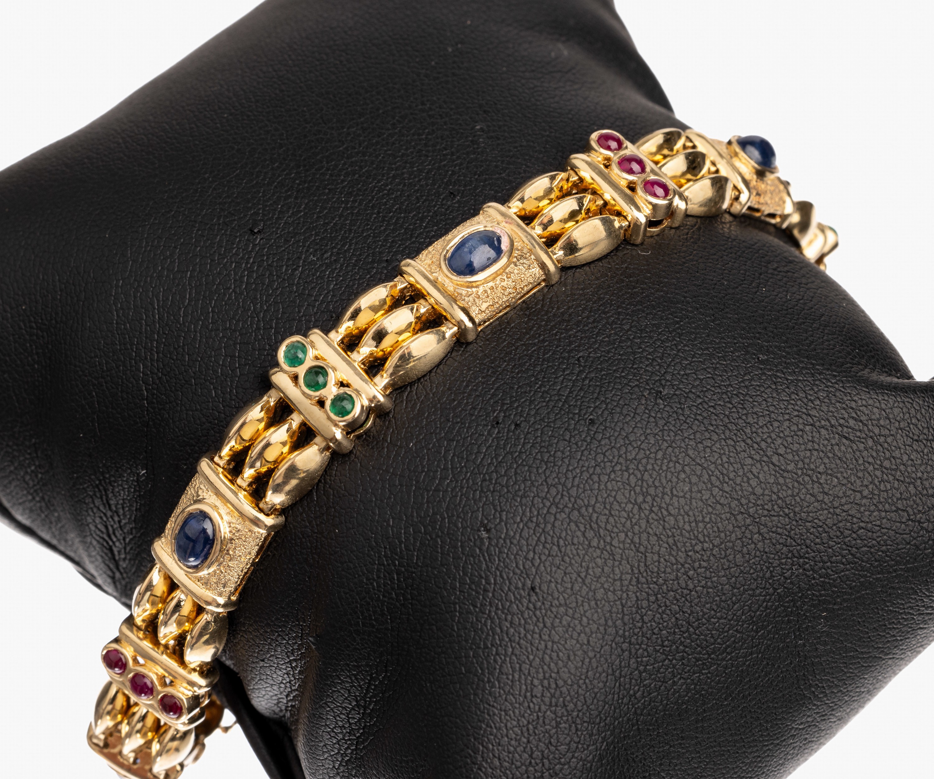 14 kt Gold Farbstein-Armband, GG 585/000, offen gearbeitet, teils strukt. und pol., 6 ovale Saphircabochons zus. ca. 4.00 ct, 9 runde Rubincabochons ...