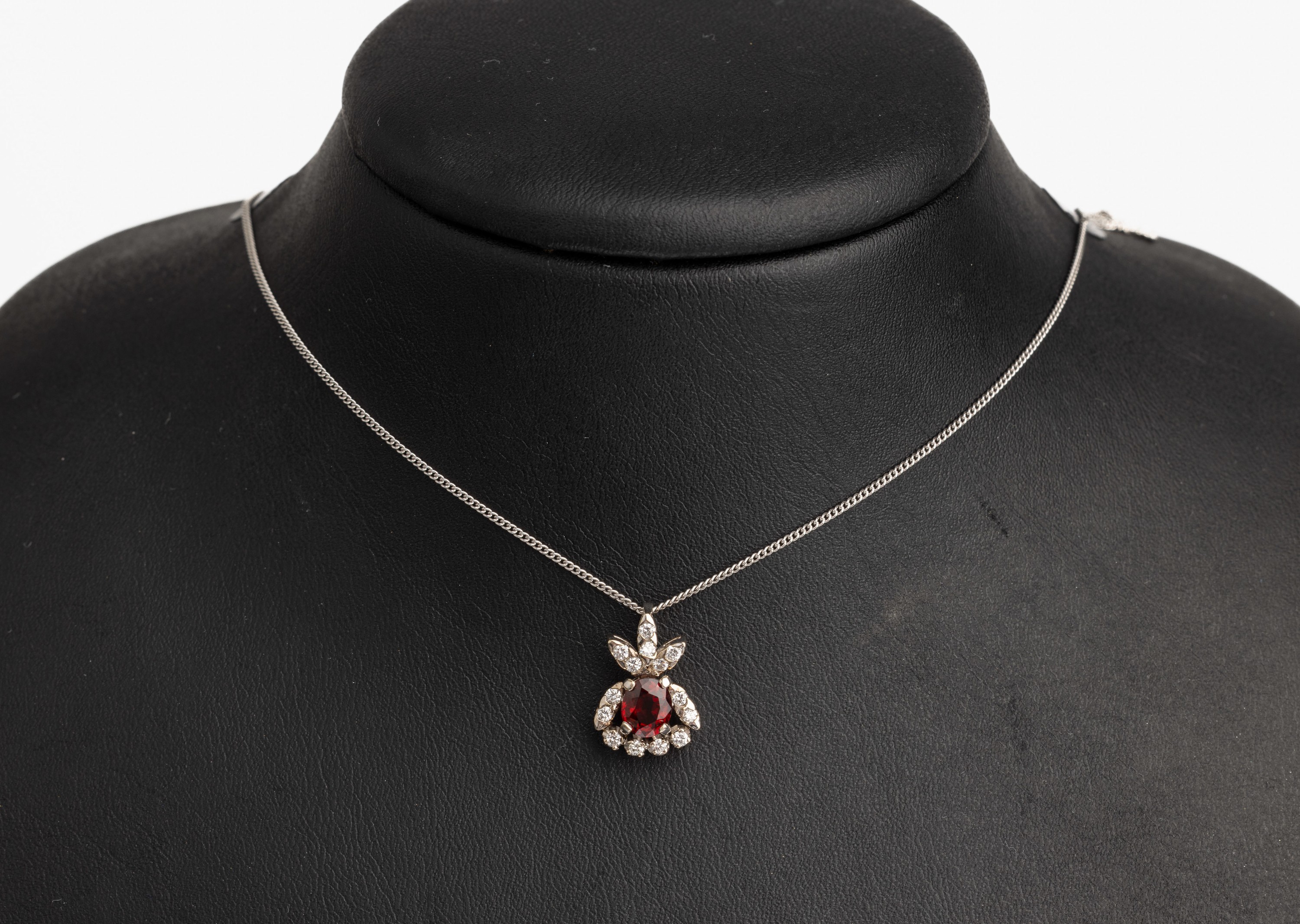 14 kt Gold Granat Brillant Anhänger, WG 585/000, ovalfacett. Granat ca. 1.0 ct, 14 Brillanten zus. ca. 0.20 ct Weiß/si, an Kette L. ca. 42 cm, ca. ...