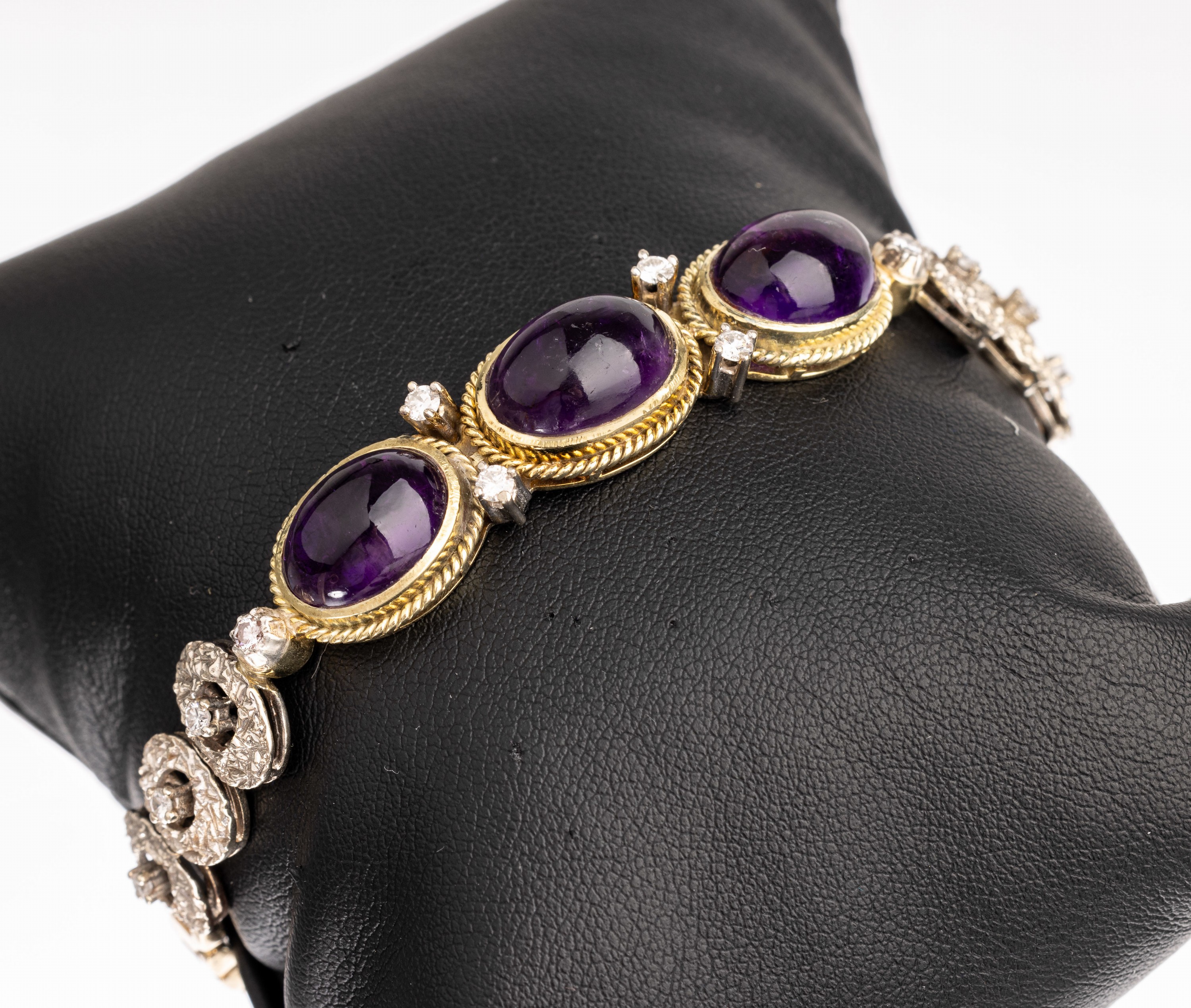 14 kt Gold Amethyst-Diamant-Armband, GG/WG 585/000, Mittelteil mit 3 ovalen Amethyst- cabochons besetzt zus. ca. 15.0 ct, Kordelrandverz., 4 ...