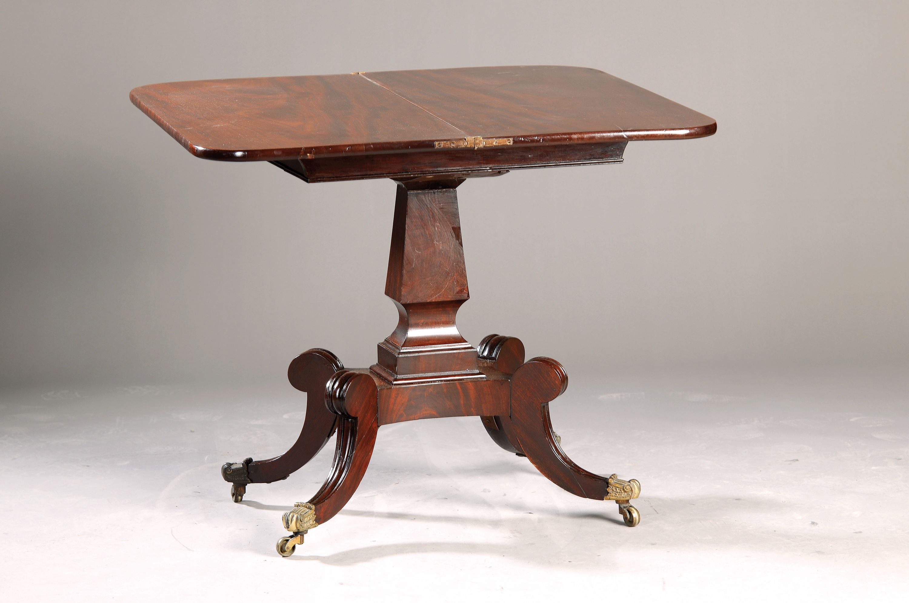 Verwandlungstisch, norddeutsch, um 1820, Mahagonifurnier z.T. massiv, vierkantige Mittelsäule auf vierpassigem Fußgesetell, Füße mit Rollen und ...
