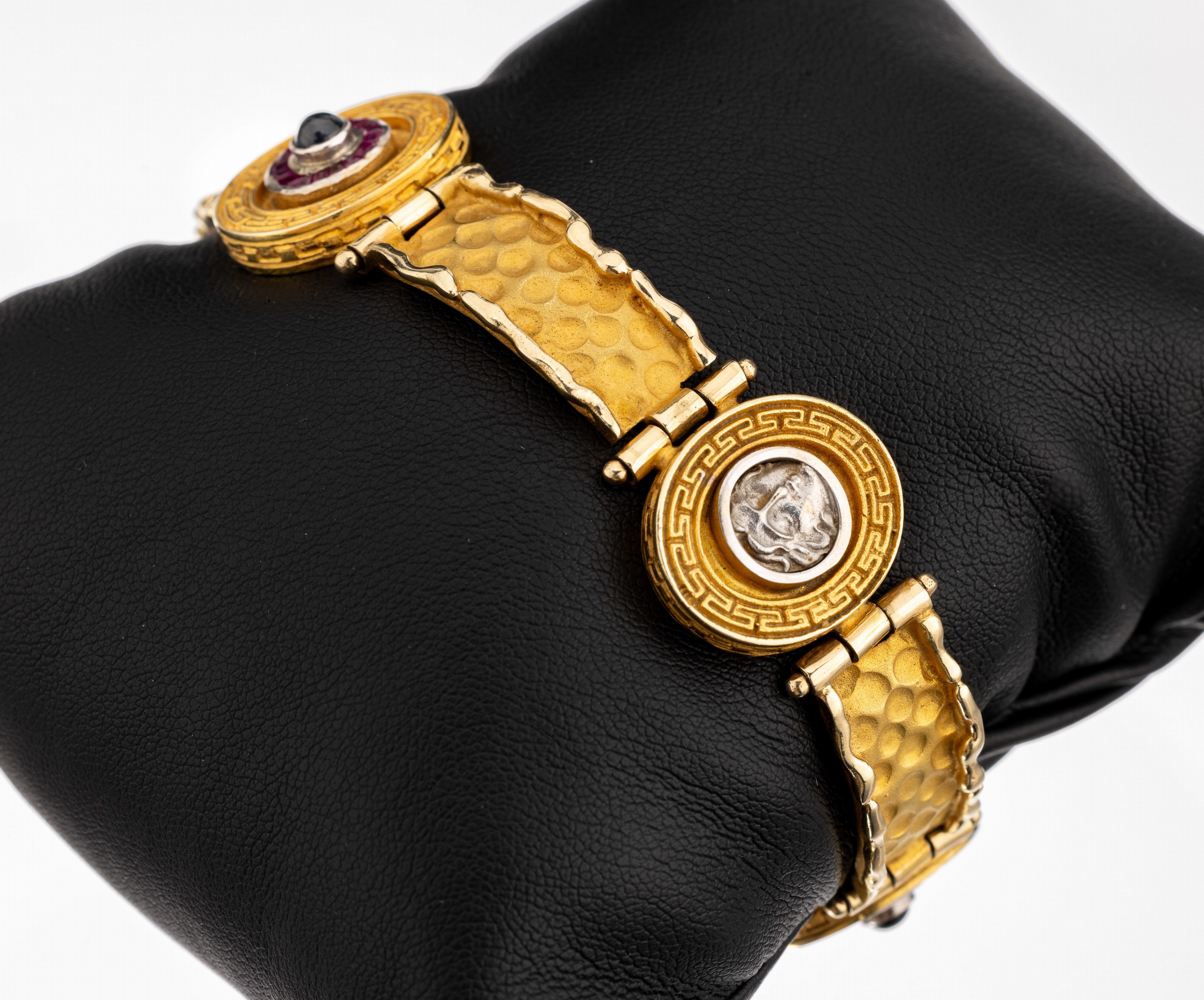 14 kt Gold Rubin-Saphir-Armband, GG 585/000, Mäandermuster, stilis. Medusenköpfe, 2 Saphir-Cabochons umgeben von Rubin-Trapezen zus. ca. 0.60 ct, ...
