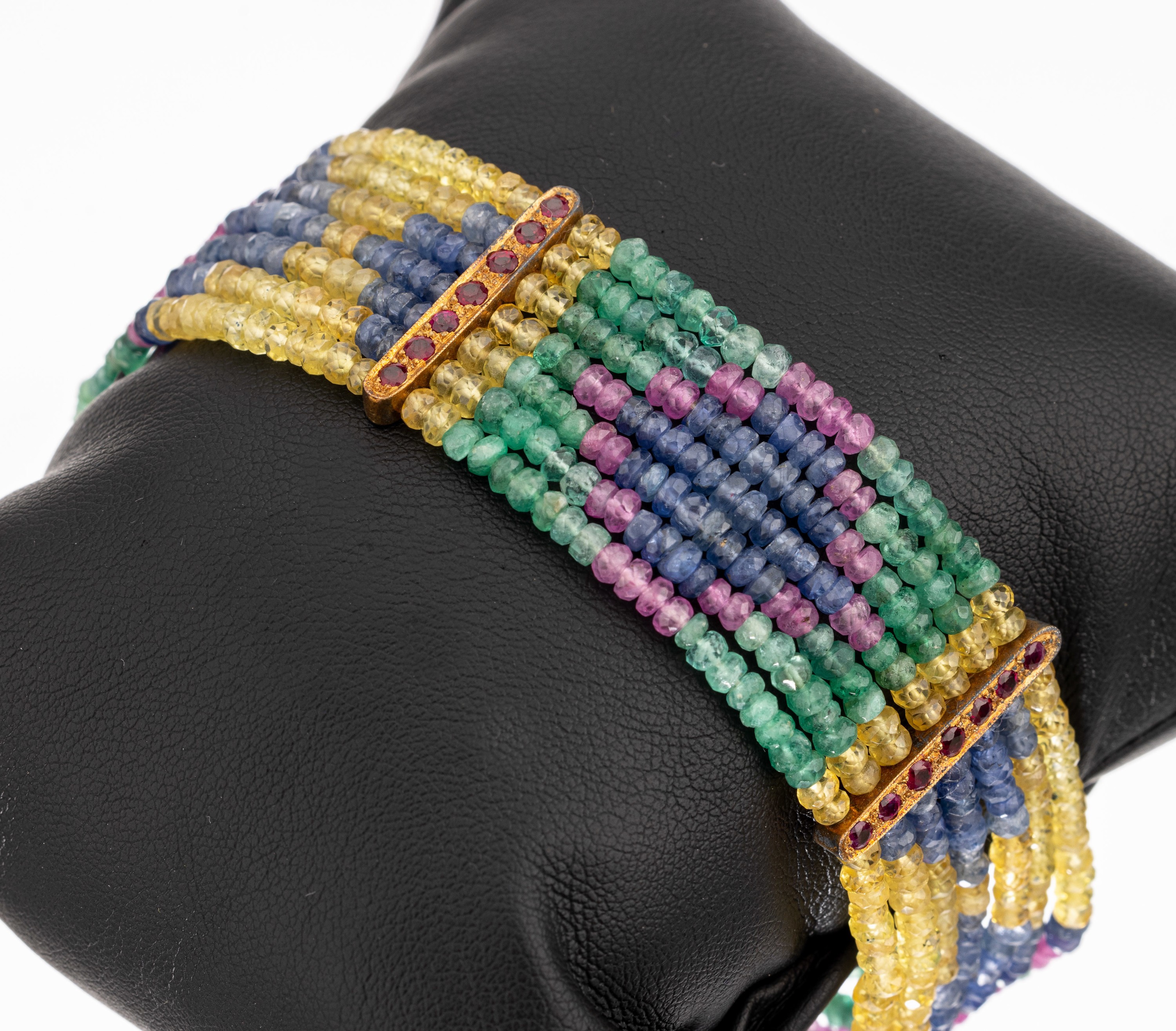 7-reihiges Farbstein-Armband, GG 750/000, Schließe und Zwischenstege mit rundfacett. Rubinen zus. ca. 0.28 ct, Stränge aus facett. Saphir-, ...