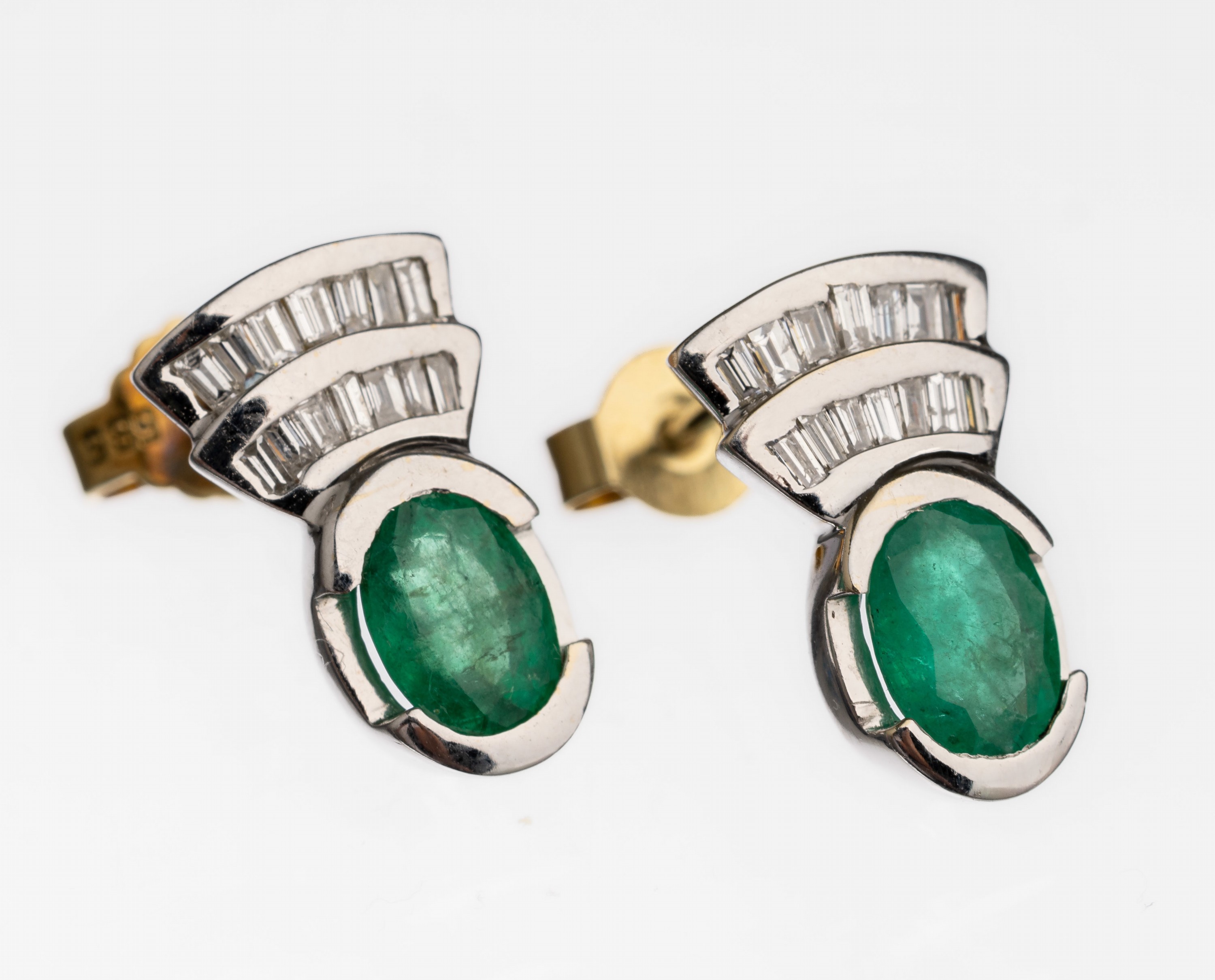 Paar 14 kt Gold Smaragd Diamant Ohrstecker, GG/WG 585/000, 2 ovalfacett. Smaragde zus. ca.1.40 ct, 30 Diamantbaguettes zus. ca. 0.60 ct feines ...
