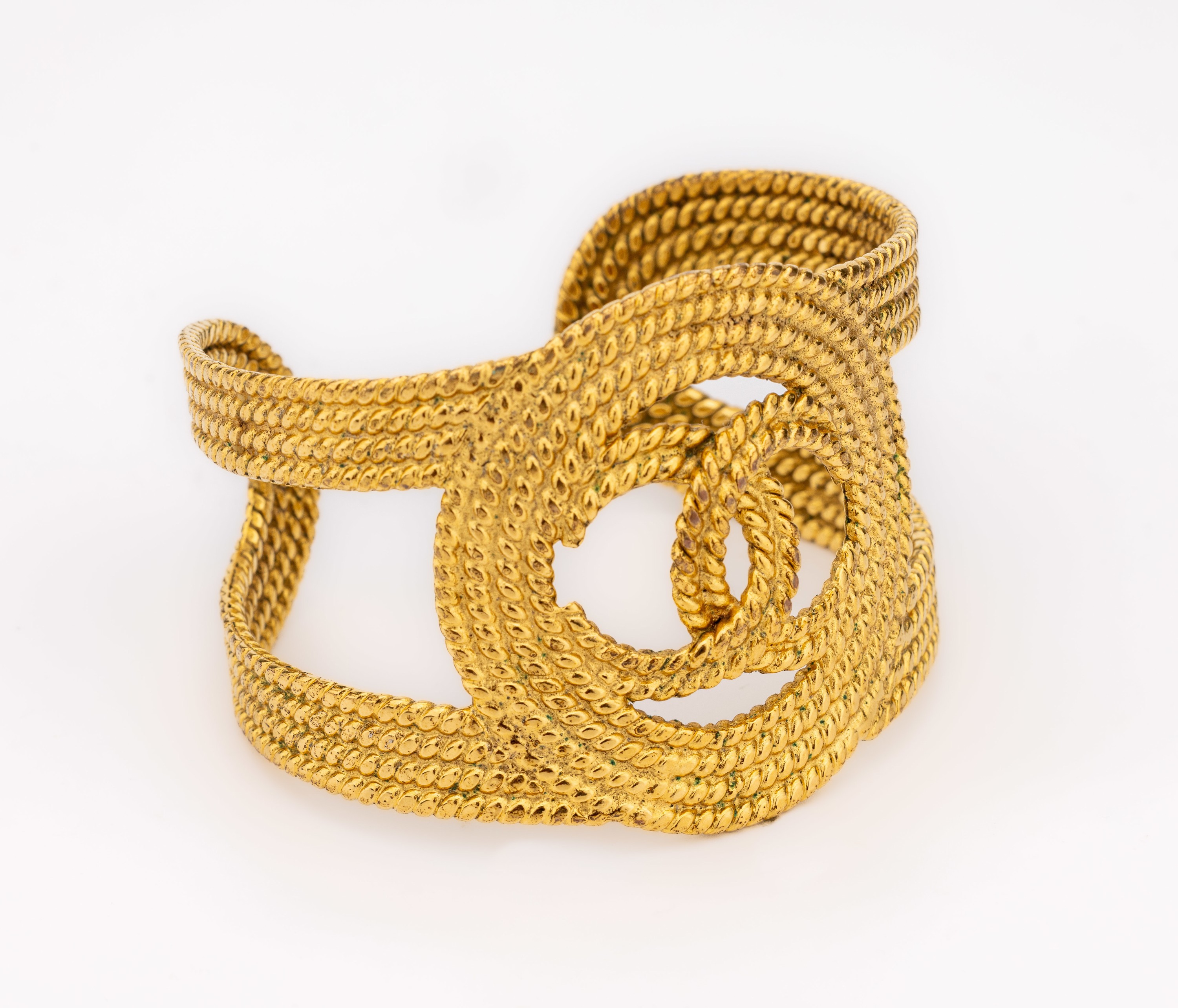 Detail a: CHANEL Armspange Paris, Metall verg., gekordeltes Design, mittig CHANEL Emblem, sign. Chanel made in France, D. ca. 6 x 5 cm, Öffnung 3 cm
