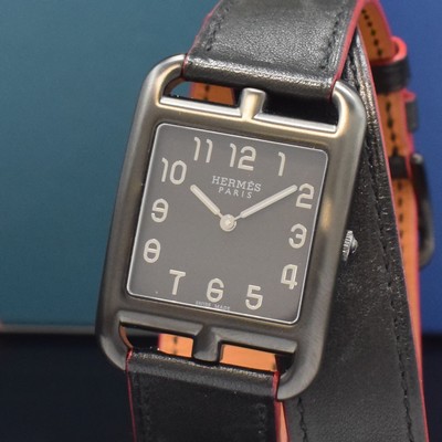 26787189a - HERMES wristwatch series Cape Cod reference CC3.711, quartz, blackened stainless steel case including original leather strap with original buckle, case back screwed-down 4- times, black dial with Arabic numerals, silvered hands, measures approx. 41 x 29 mm, Hermes storage back enclosed, unworn stock, condition 1-2