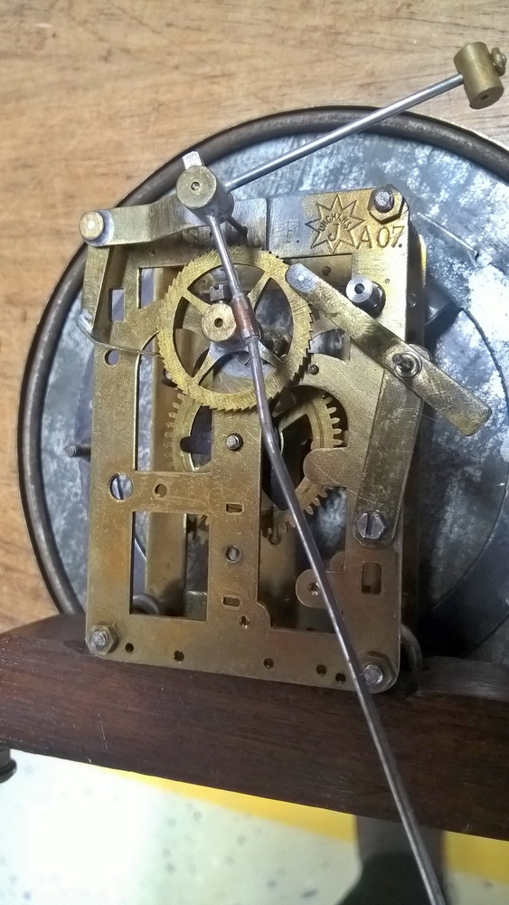 Detail d: Wanduhr, elektrisch, um 1930, Holzgehäuse verziert u. profiliert, sek. lackiert, Giebelabschluss, Türverschluss rechts mittels einzelner ...