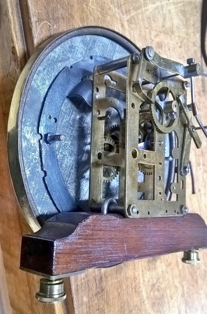 Detail f: Wanduhr, elektrisch, um 1930, Holzgehäuse verziert u. profiliert, sek. lackiert, Giebelabschluss, Türverschluss rechts mittels einzelner ...