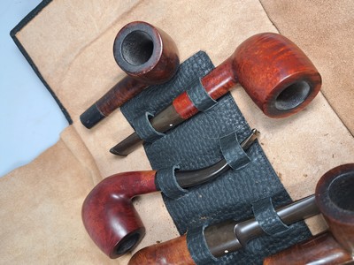 26790376b - Pipe shelf and 22 branded pipes, branded pipes inter alia 5 x Dunhill, Nording, Briar, Bang, 3 x Savinelli, Killarmey, Vauens, Dansk and Peterson, inter alia, in addition one Meerschaum pipe, all used, partly with traces of usage, corner shelf in oak with floral carving, in addition slightly accessories, 84 x 35 cm, Thigh depth 25 cm in addition tobacco vessel, two pipes without mouthpiecee