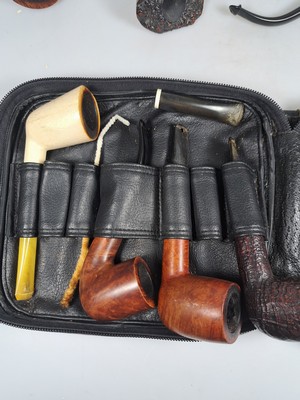 26790376e - Pipe shelf and 22 branded pipes, branded pipes inter alia 5 x Dunhill, Nording, Briar, Bang, 3 x Savinelli, Killarmey, Vauens, Dansk and Peterson, inter alia, in addition one Meerschaum pipe, all used, partly with traces of usage, corner shelf in oak with floral carving, in addition slightly accessories, 84 x 35 cm, Thigh depth 25 cm in addition tobacco vessel, two pipes without mouthpiecee