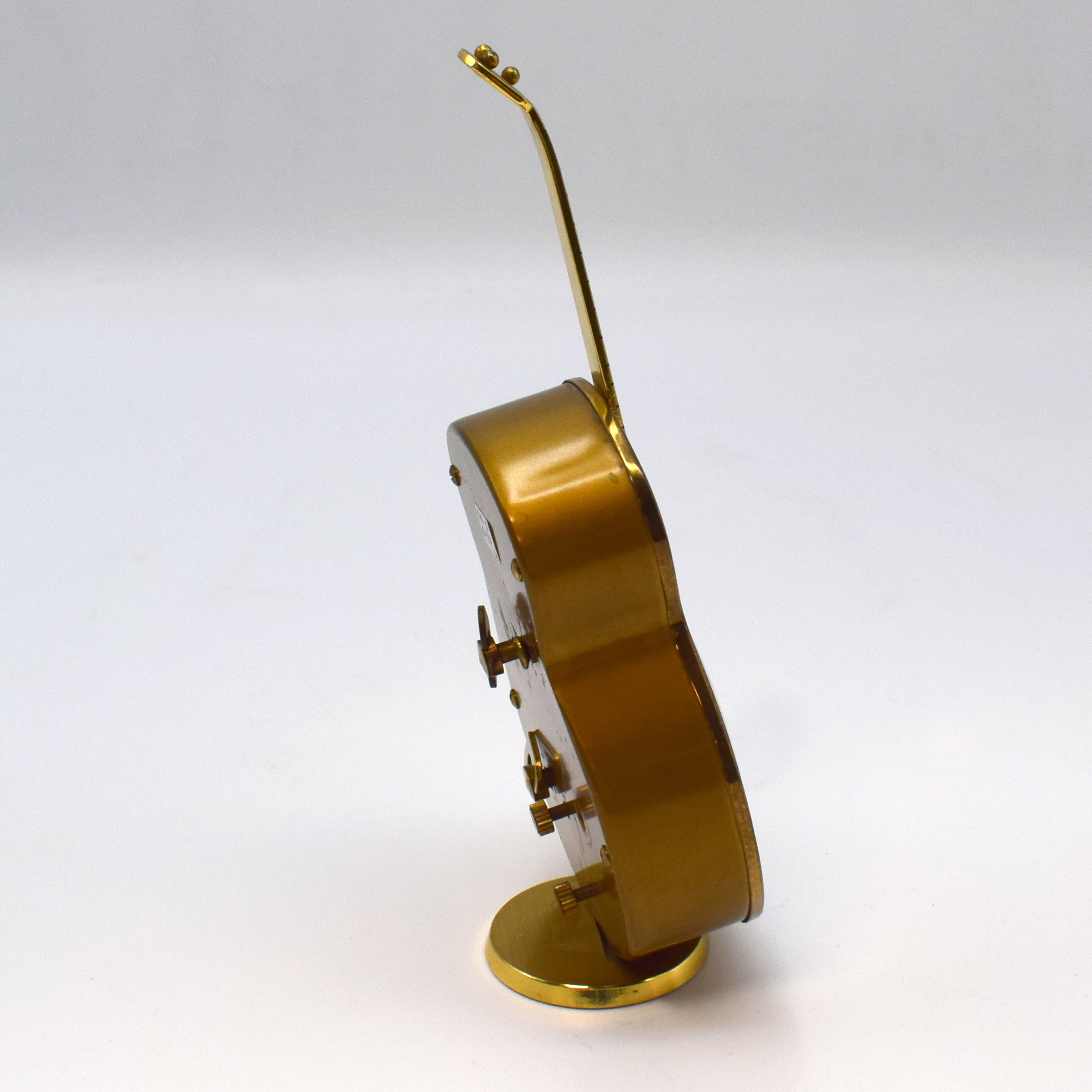 Detail b: SWIZA / PETER Konvolut von 2 Musik-Weckern, Schweiz / Deutschland um 1950, 1) SWIZA, lack. Messinggeh. in Gitarren-Form, silb. ovales Zifferbl., H. ...