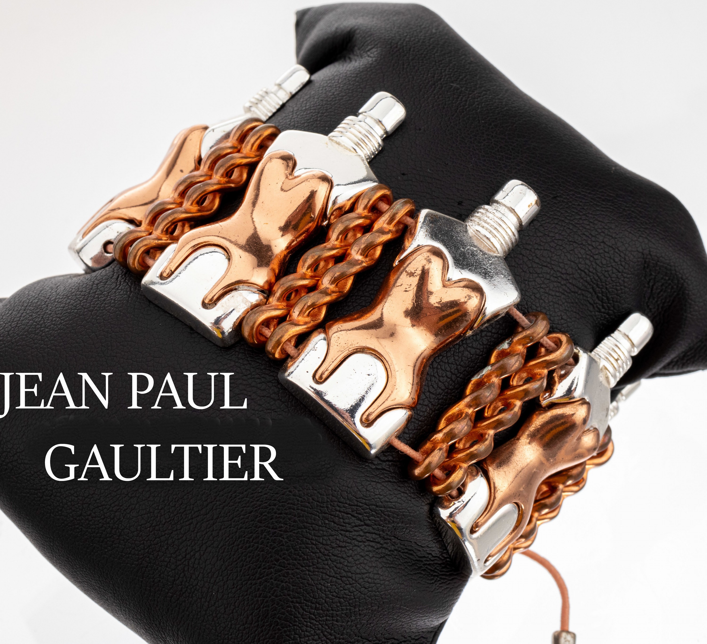 Armband JEAN PAUL GAULTIER, Metall teilweise versilbert, kupferfarb. Glieder in Form von Parfumflakons, kupferfarbene Korsetts, rosafarb. ...
