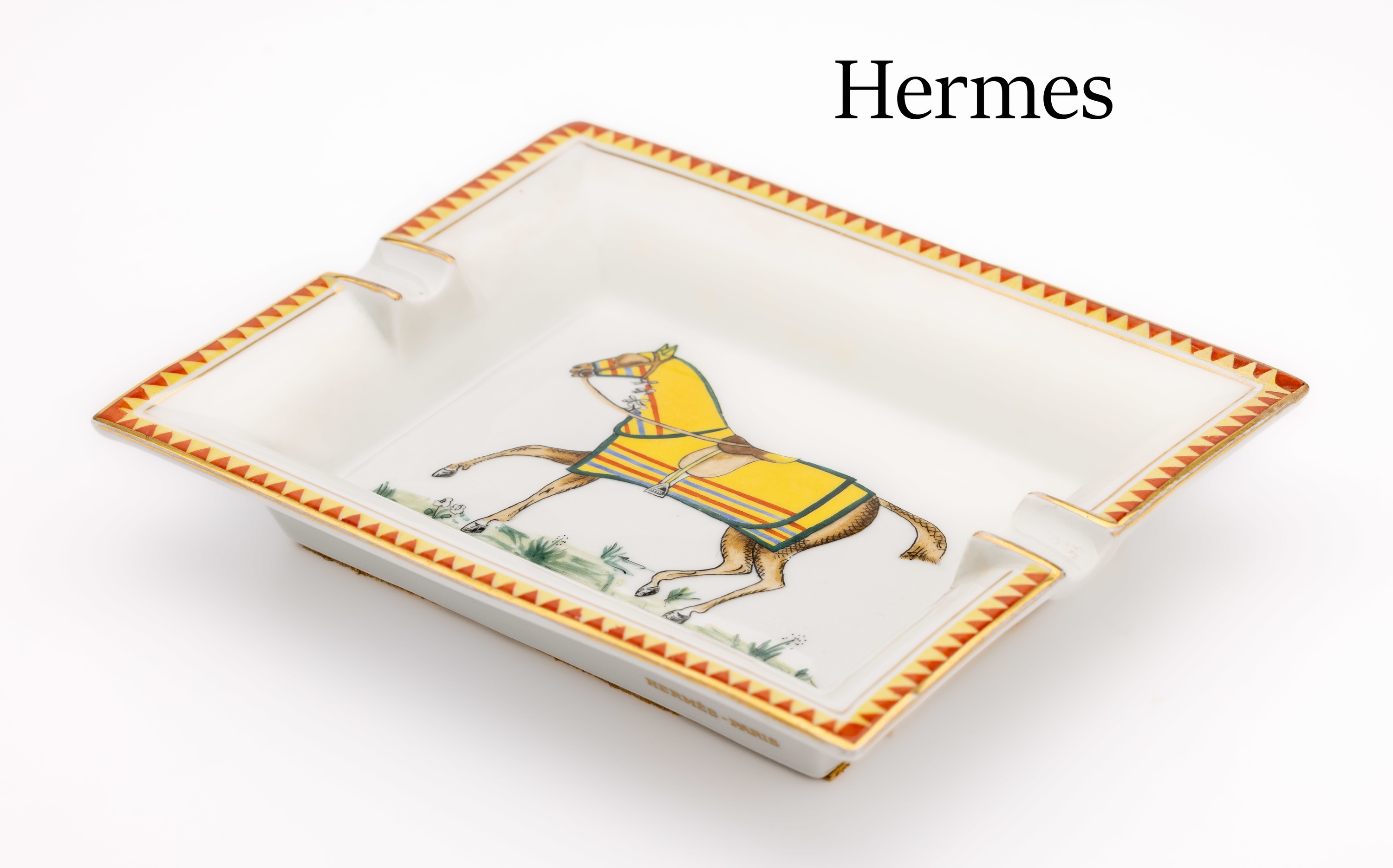HERMES Aschenbecher, Porzellan mit polychromen Dekor, Pferd mit bunter Decke, Fahne kaisergelb, Rand goldfarben, ca. 19.5 x 16 cm,Boden mit gelbem ...