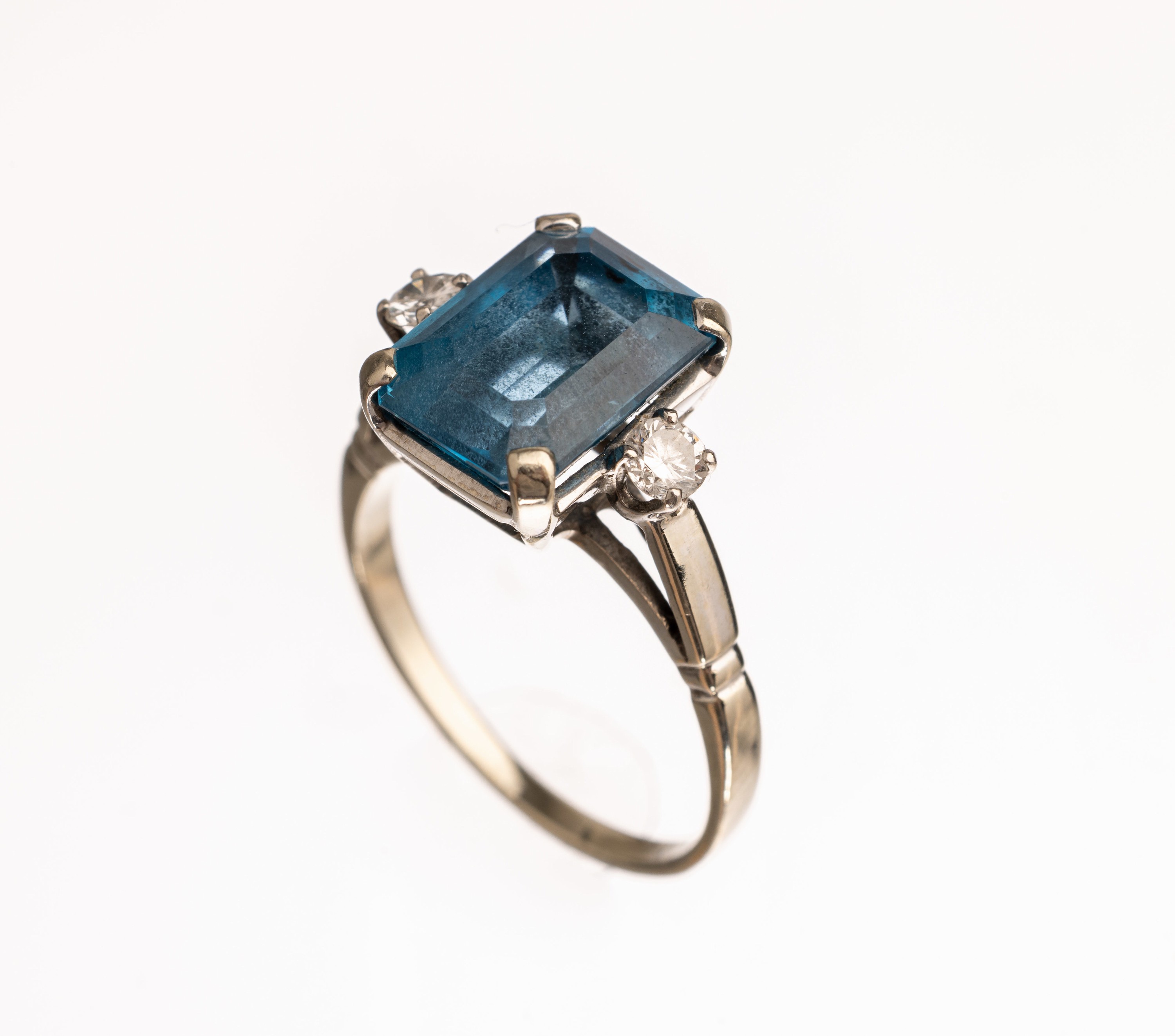 18 kt Gold Farbstein Diamant Ring, WG 750/ 000, mittig rechteckig facett. blauer Farbstein, wohl Coelestin, 2 Diamanten zus. ca. 0.16 ct Weiß/si, ...