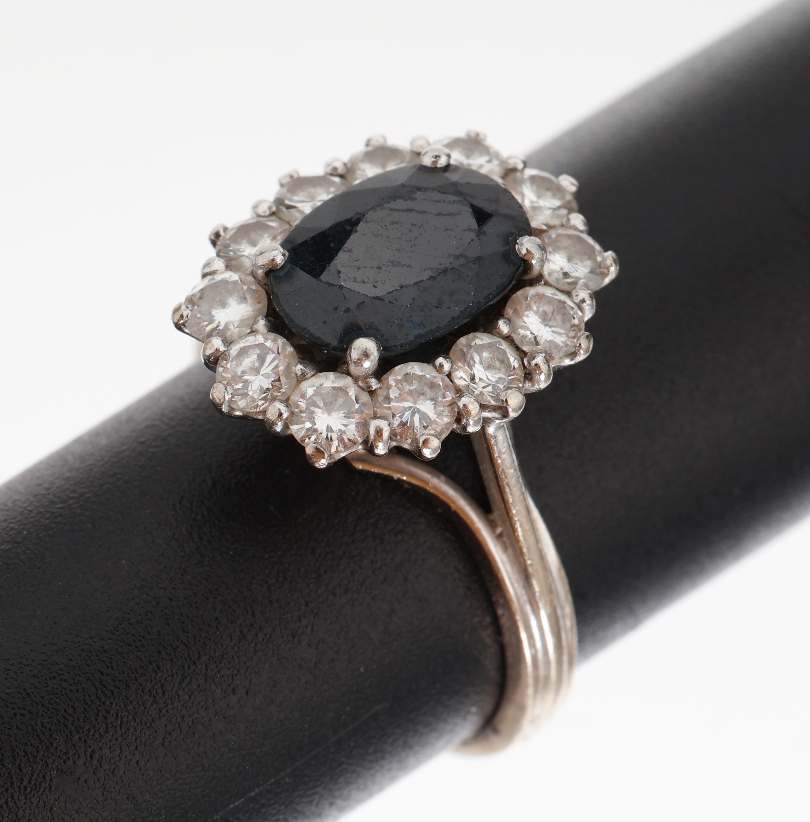 18 kt Gold Saphir-Brillant-Ring , WG 750/000, ovalfacett. Saphir ca. 2 ct, umgeben von 12 Brillanten zus. ca. 0.60 ct Weiß/si, RW53, ca. 5.4 g