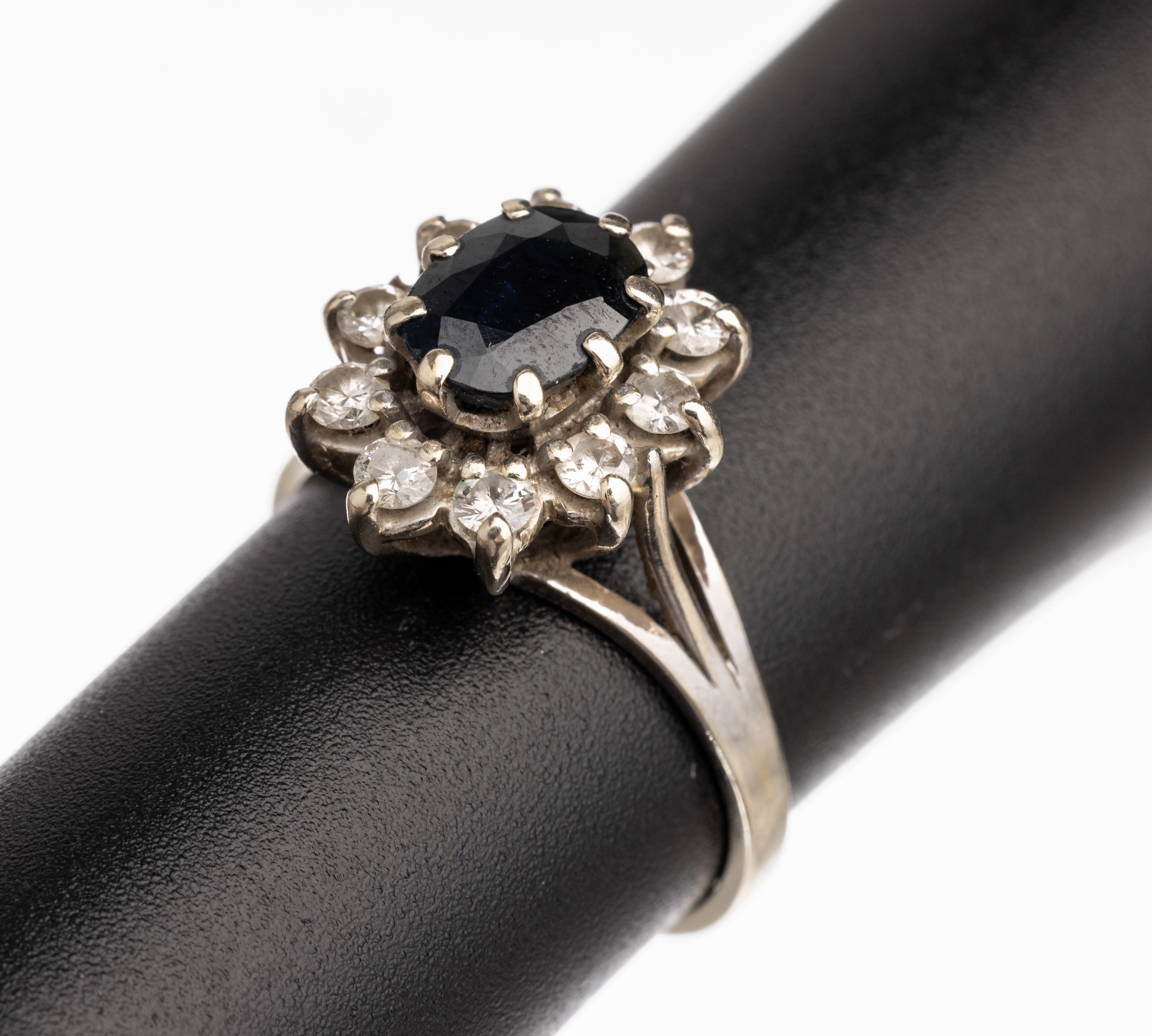 18 kt Gold Saphir-Diamant-Ring, WG 750/000,ovalfacett. Saphir ca. 0.7 ct umgeben von 10 Diamanten zus. ca. 0.70 ct Weiß/si, RW 54, ca.4.1 g