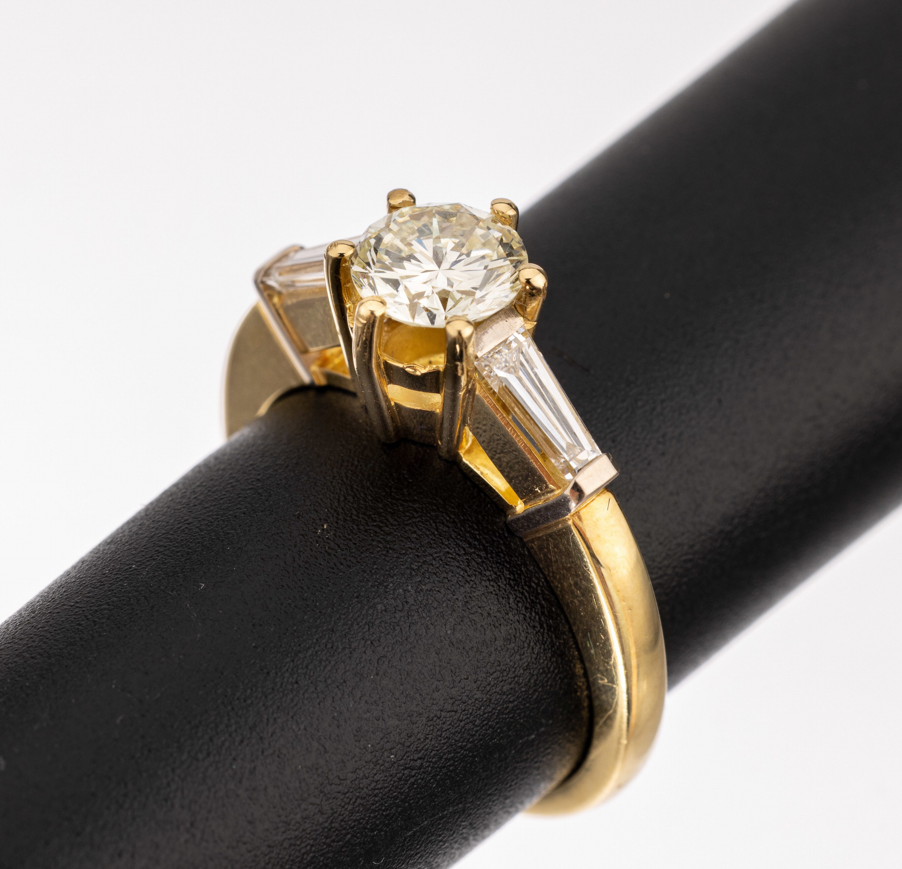 18 kt Gold Diamant-Ring, GG 750/000, 1 Brillant ca. 1.01 ct Weiß/si, 2 Diamant- Trapeze zus. ca. 0.50 ct Weiß/si, ca. 6.6 g, RW 56