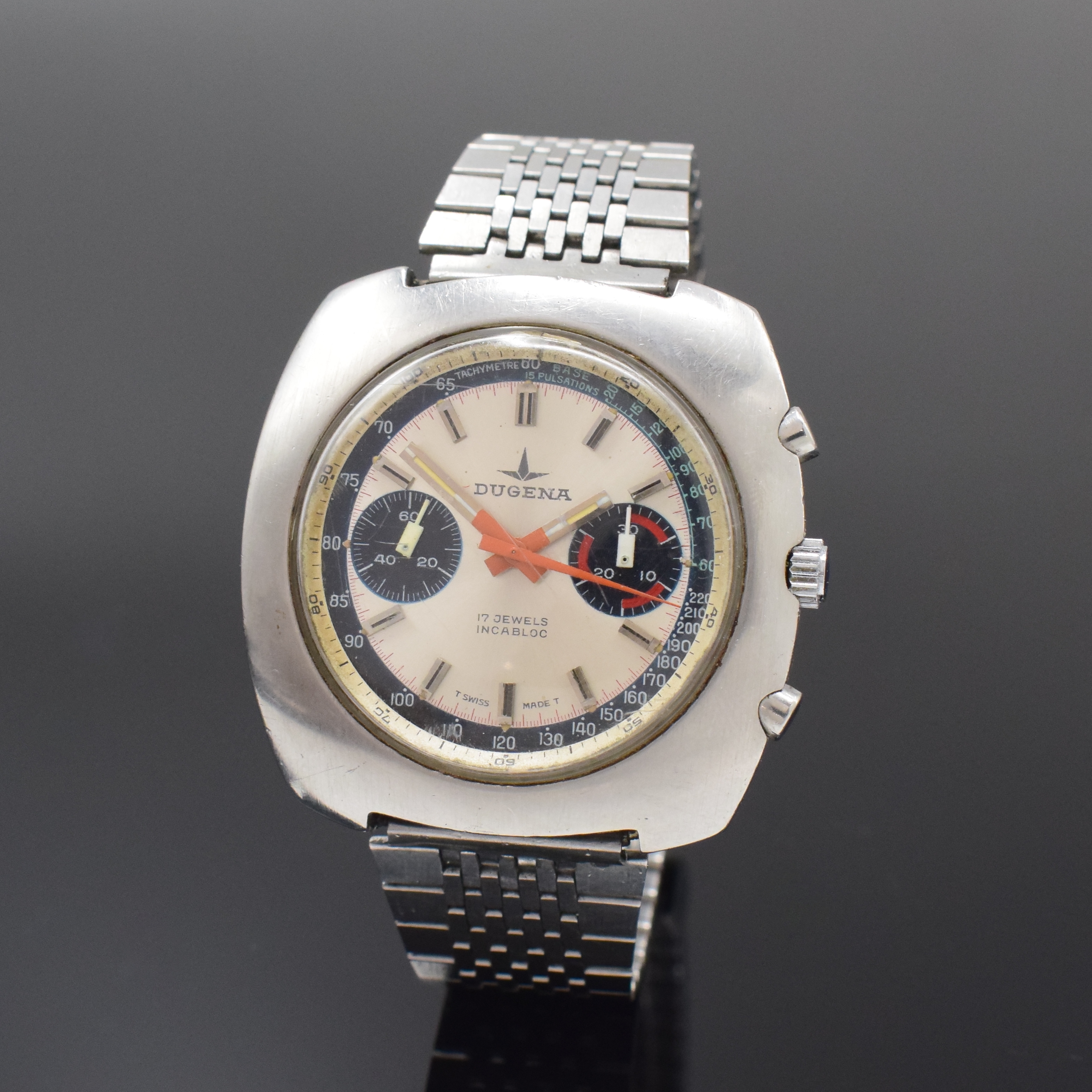 DUGENA Armbandchronograph mit Kaliber Valjoux 7733 in Stahl, Schweiz um 1975, Handaufzug, Boden verschr., neutr. Band, silb. Zifferbl. m. aufges. ...