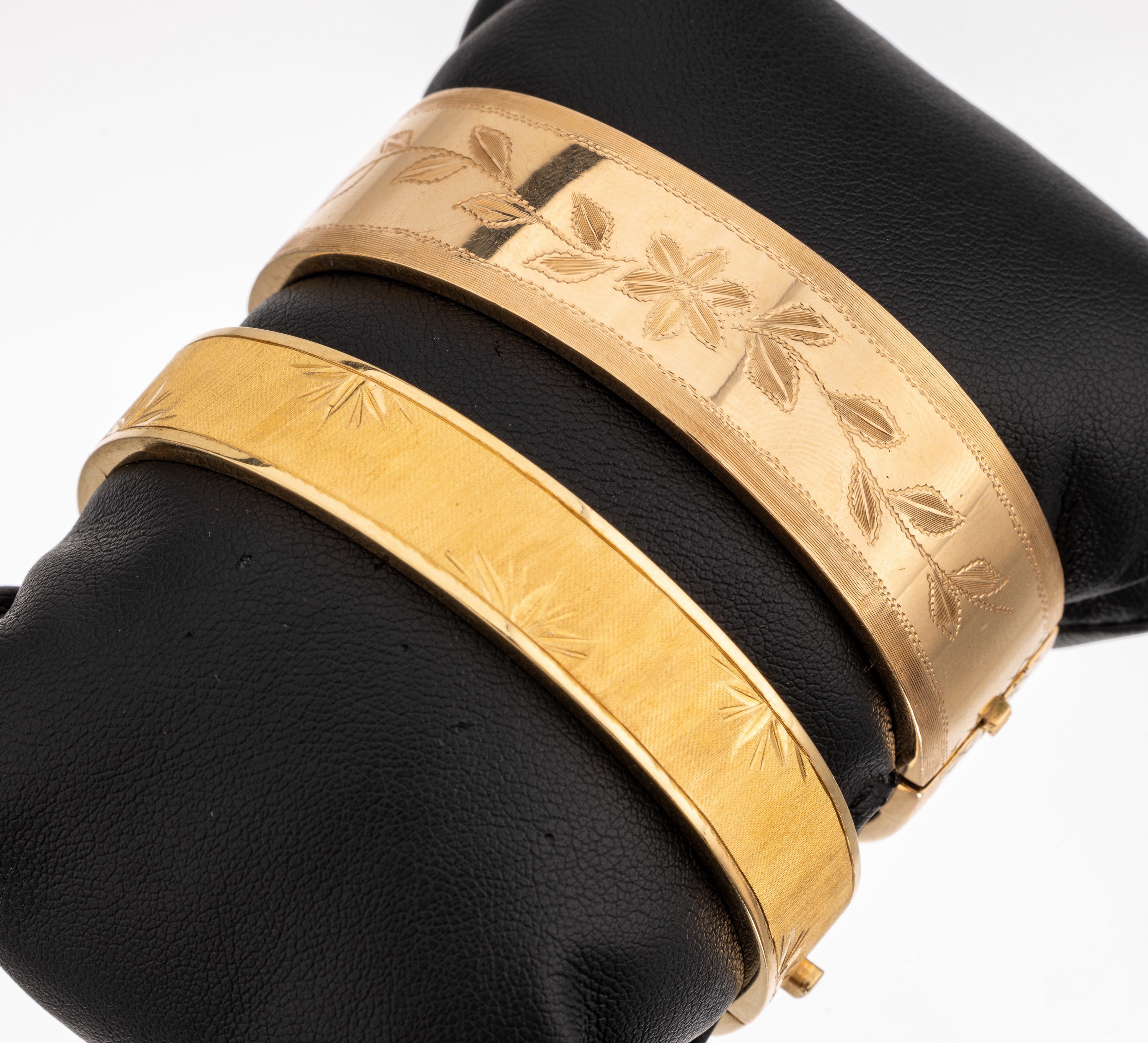 2 18 kt Gold Armreife, ca. 750/000, fein sat. und floral grav., D. ca. 6 x 5.2 cm, versch. Breiten, ca. 71.7 g