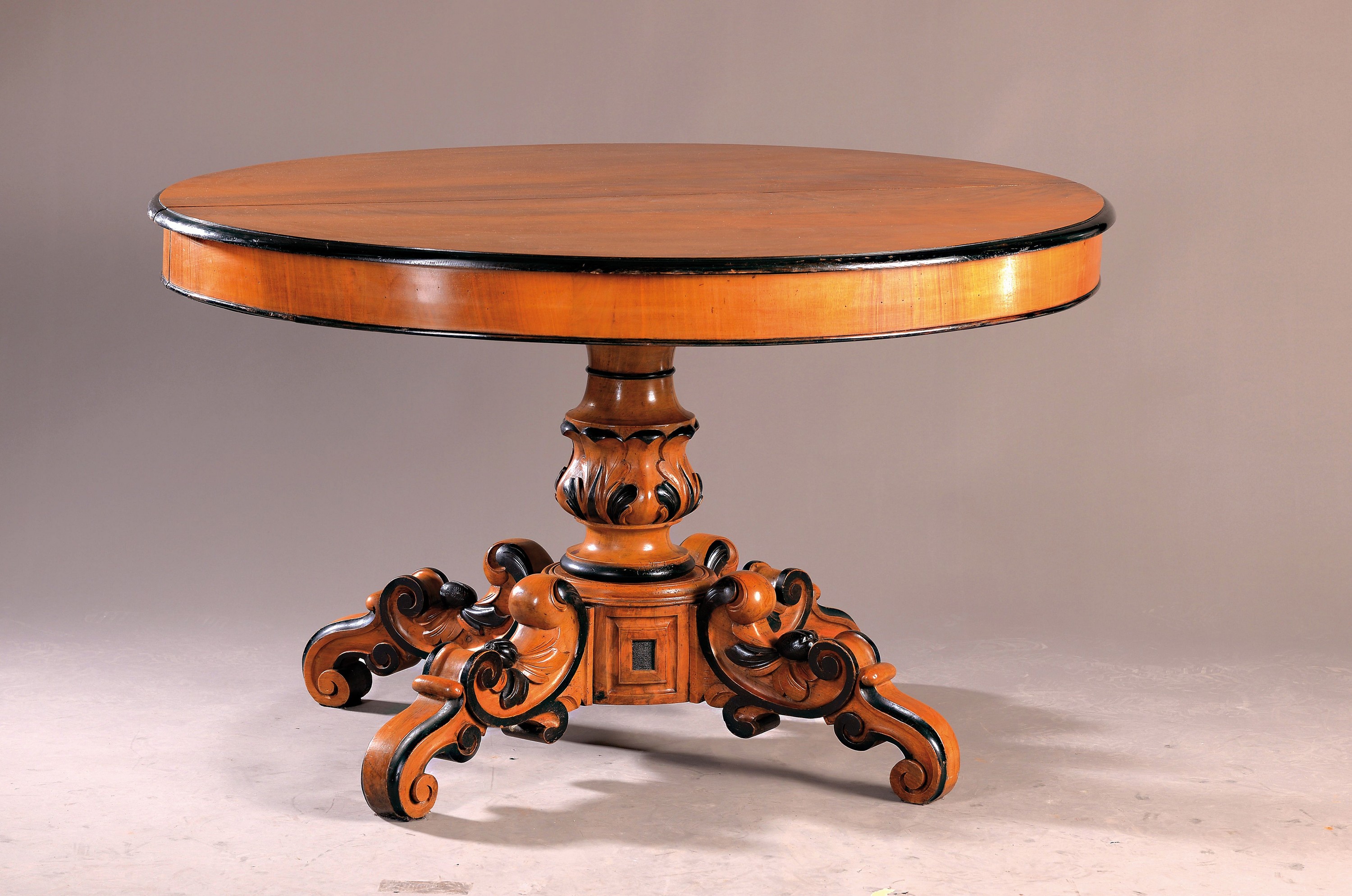 Salontisch, Spätbiedermeier, um 1880, Nußbaum massiv, z.T. in schwarz ebonisiert, kräftige Balustersäule auf Voluten, Einlegebretter nicht ...