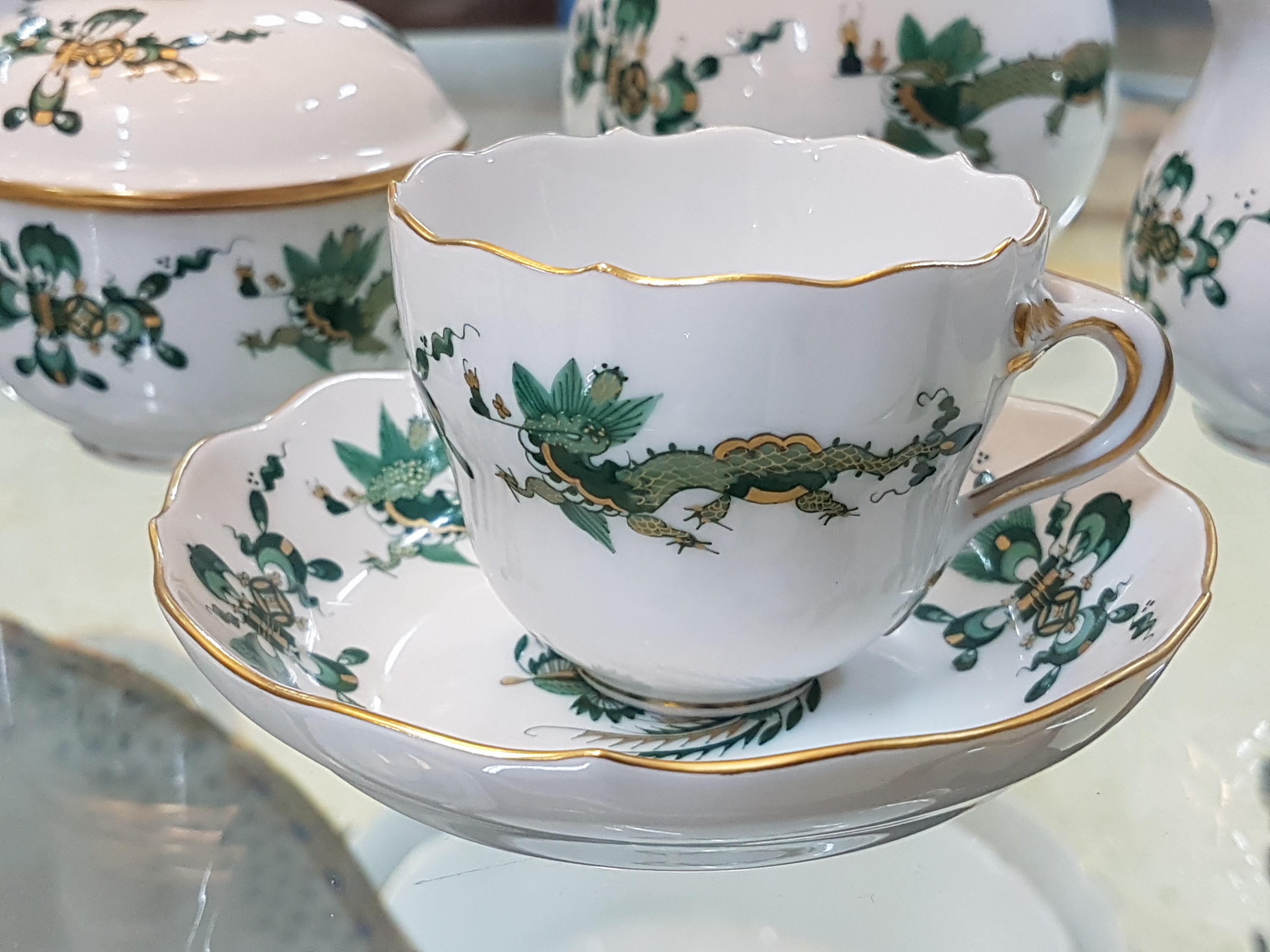 Detail b: Mokkaservice, Meissen, 20. Jh., 1. Wahl, reicher Drachendekor in grün goldschattiert, Kanne, Milchkännchen, Zuckerdose, 3 Tassen mit Untertassen, ...