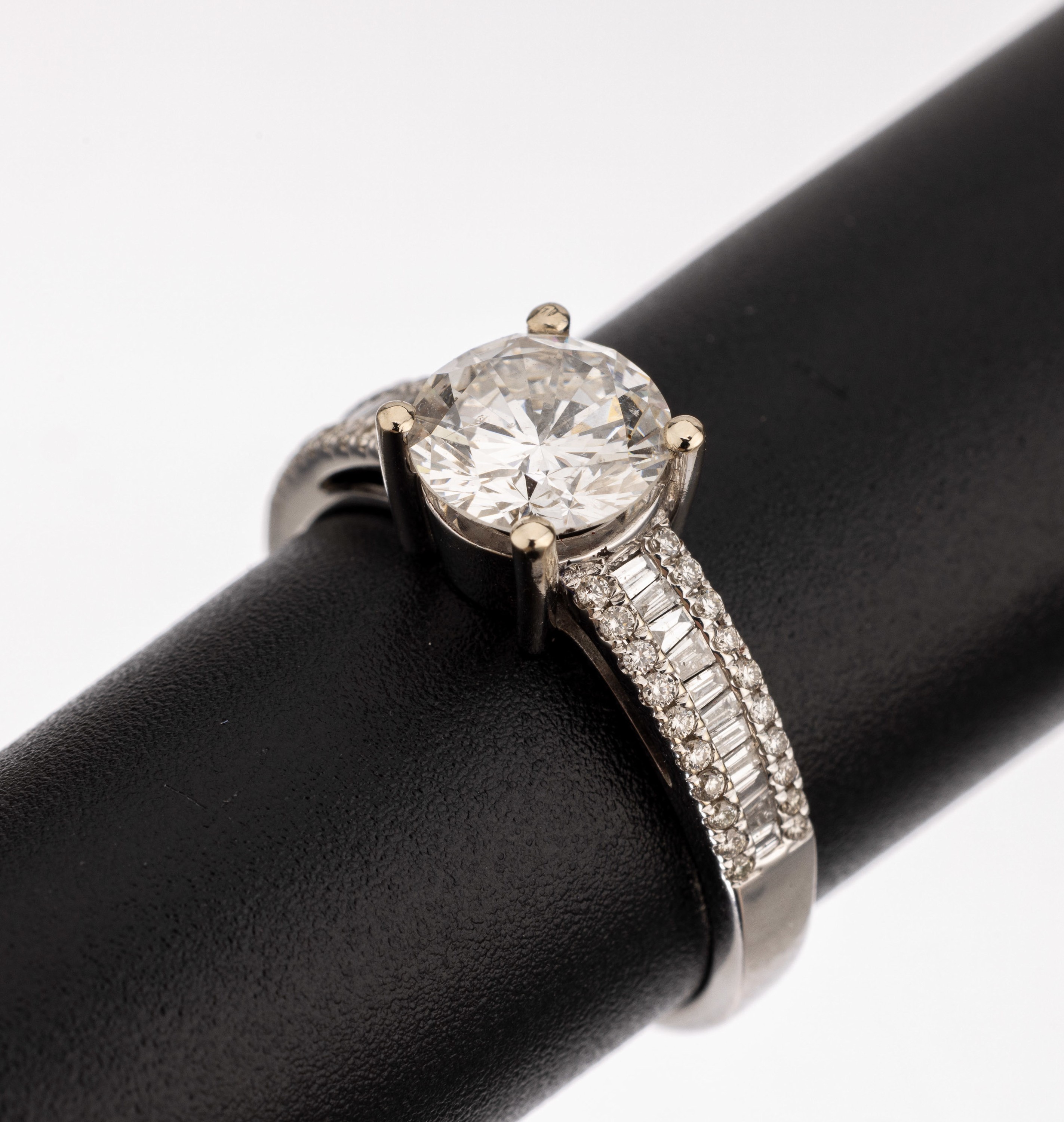 18 kt Gold Diamant-Ring, WG 750/000, Brillant-Solitär ca. 1.36 ct feines Weiß(F)/ si2, seitliche Brillanten und Diamantbaguetteszus. ca. 0.31 ct ...