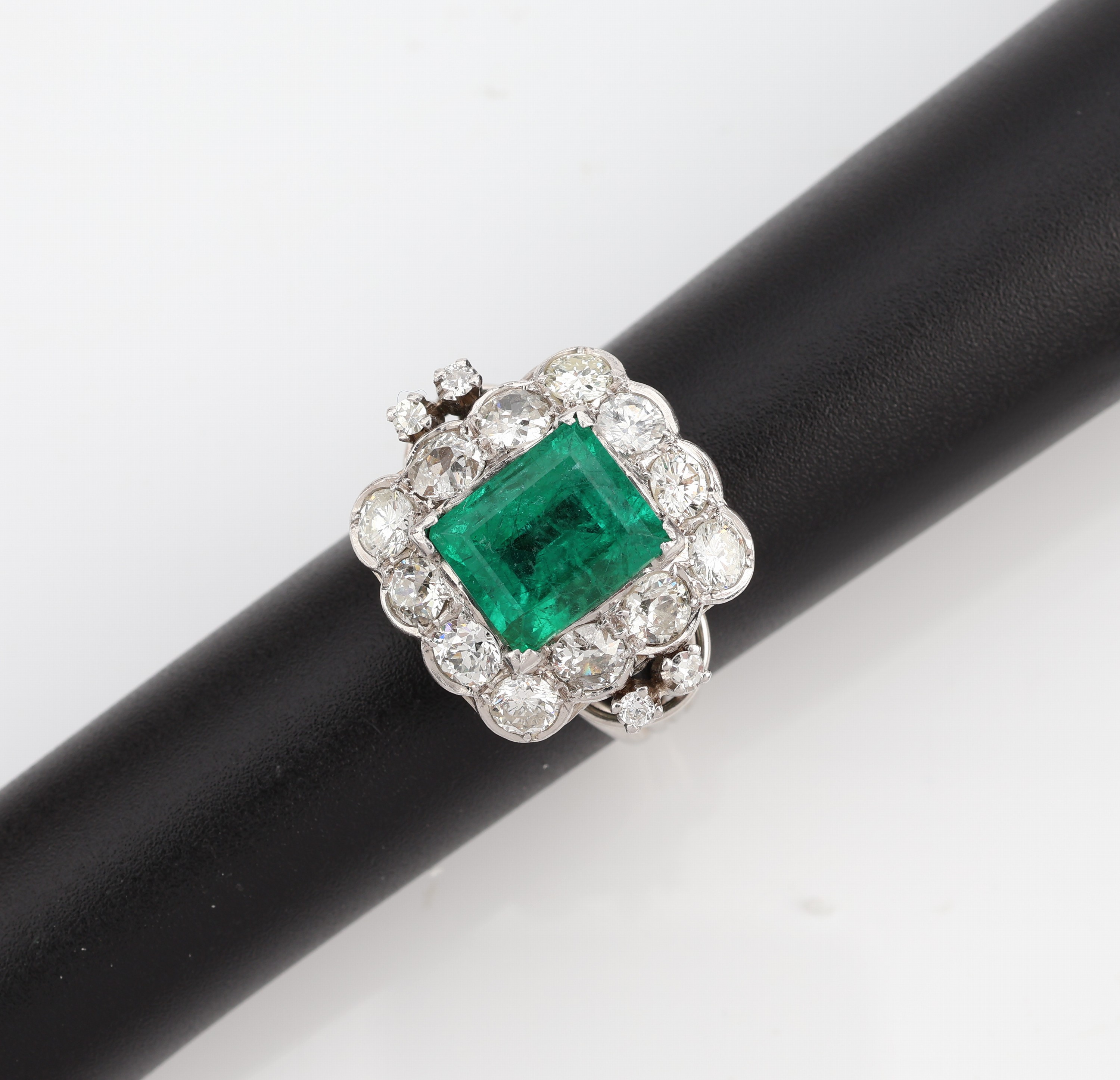 18 kt Gold Smaragd-Diamant-Ring, um 1920, WG 750/000, mittig ein kolumbianischer Smaragdca. 3.00 ct, umgeben von 2 8/8-Diamanten und 14 ...