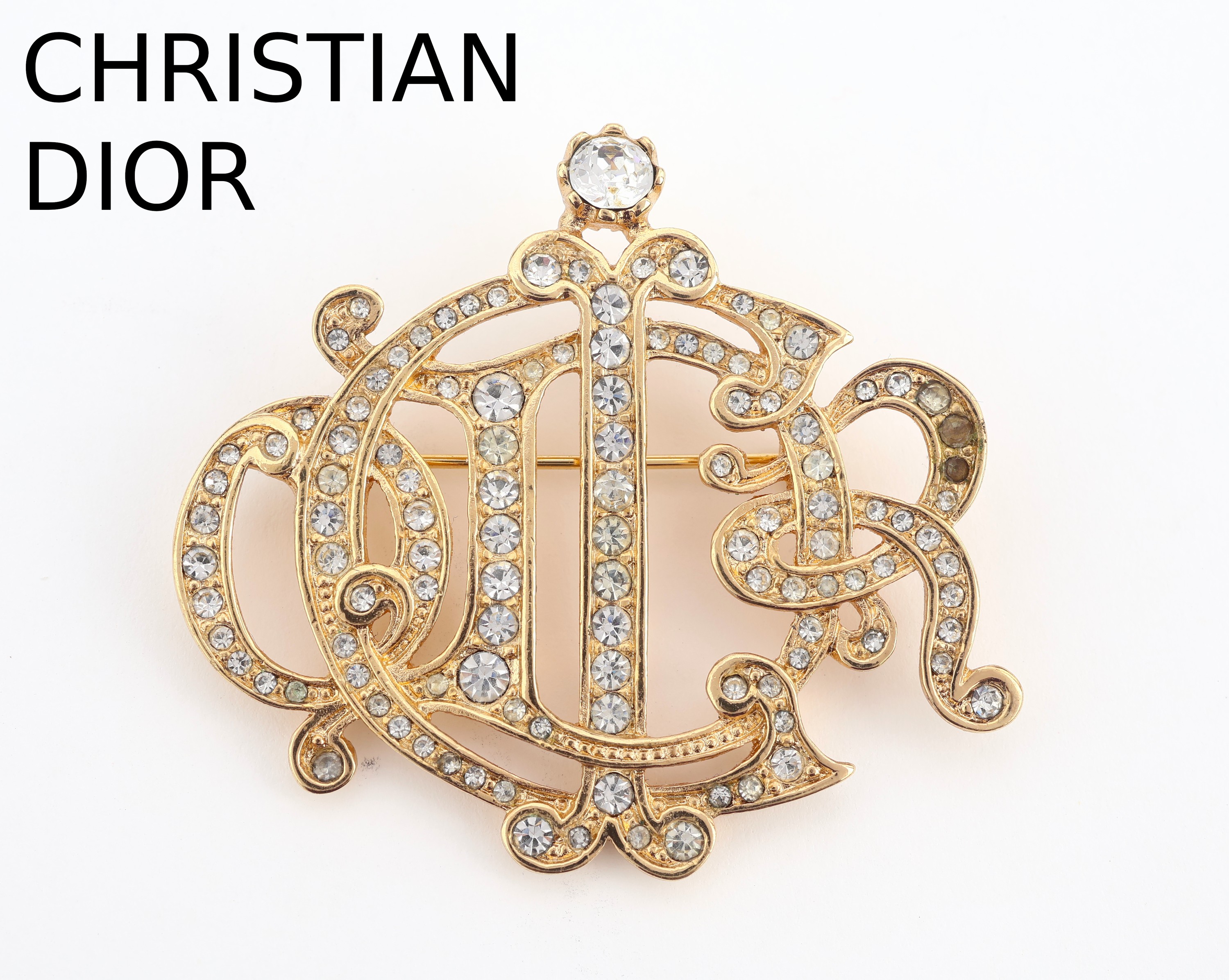 CHRISTIAN DIOR Brosche, Metall verg., 1980er Jahre, ligierter Schriftzug mit farblosen Strasssteine, Anlehnung an eine Gürtelschließe, sign., ca. ...