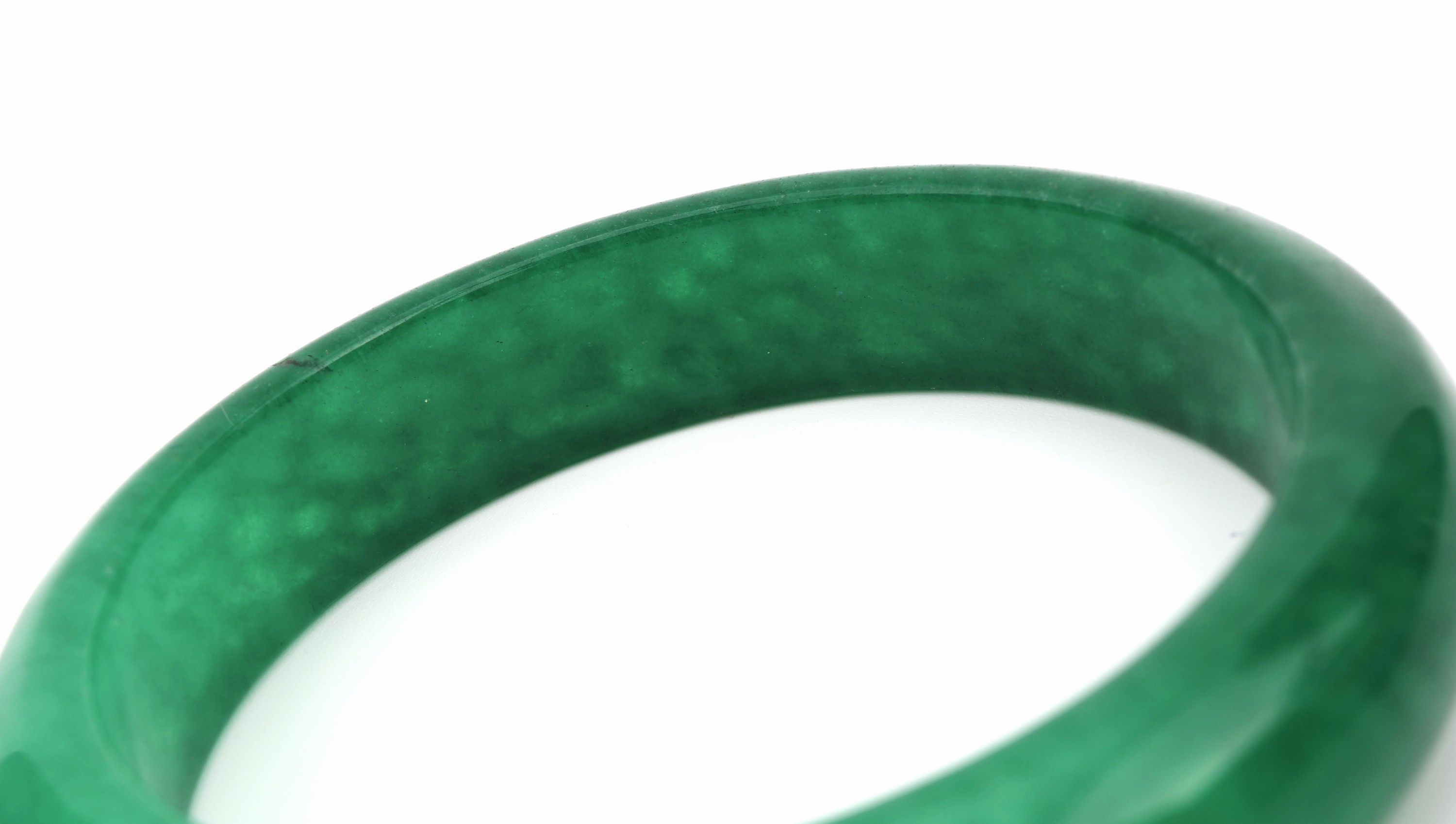 Detail a: Jade-Armreif, aus einem Stück geschnitten, B. ca. 1.5 cm, D. ca. 6.4 cm, in Etui